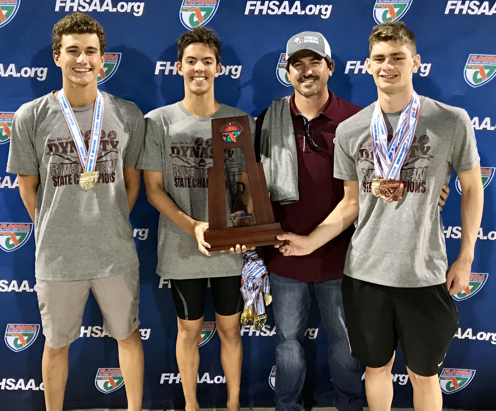 Nico Hernandez-Tome, Brendon Firlie, coach Brent Arckey and Brett Riley celebrate Riverview High boys swimming's four-peat.