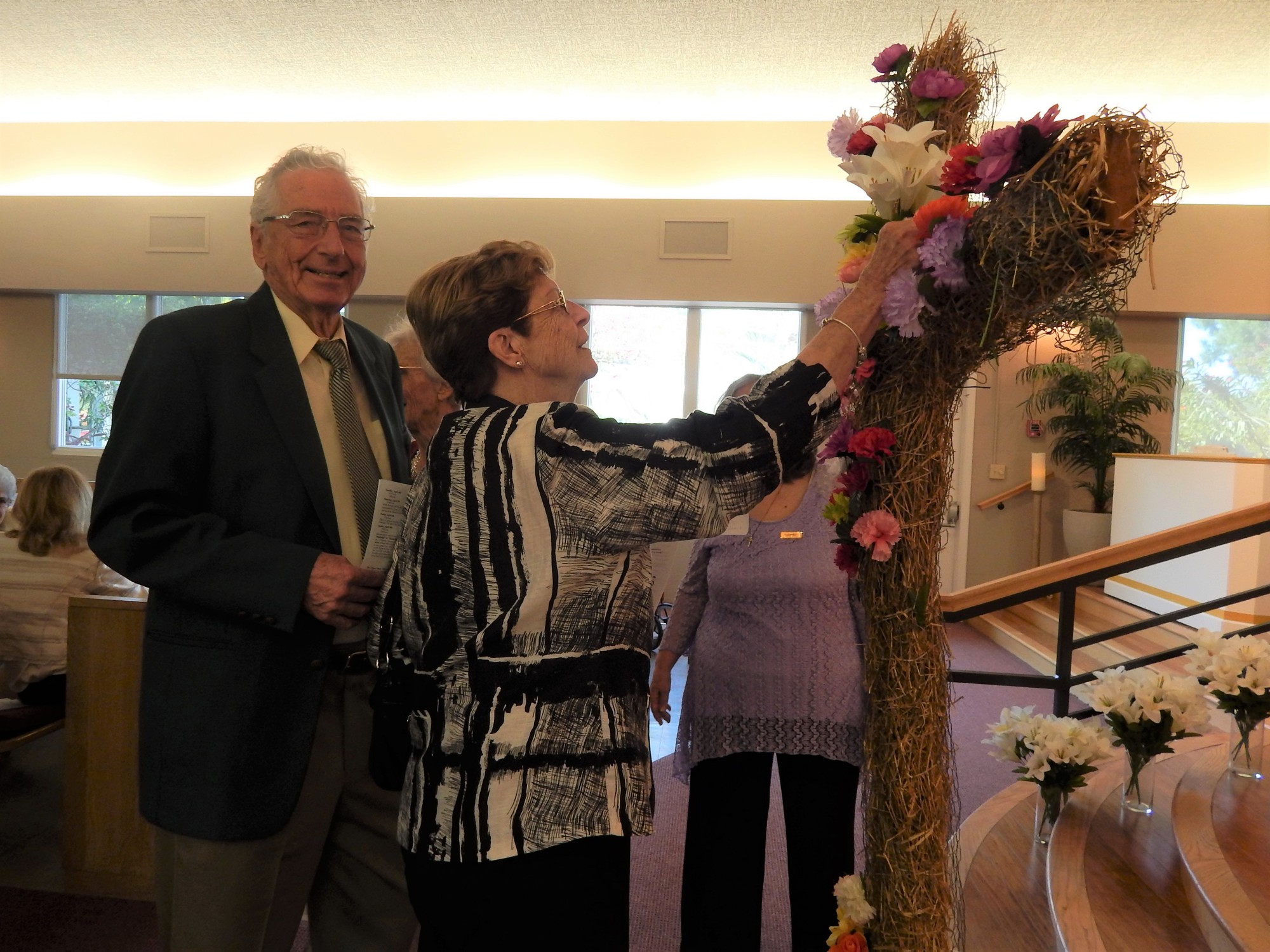 John Chalmers and wife Debbie add their flowers to the cross.    Courtesy photo