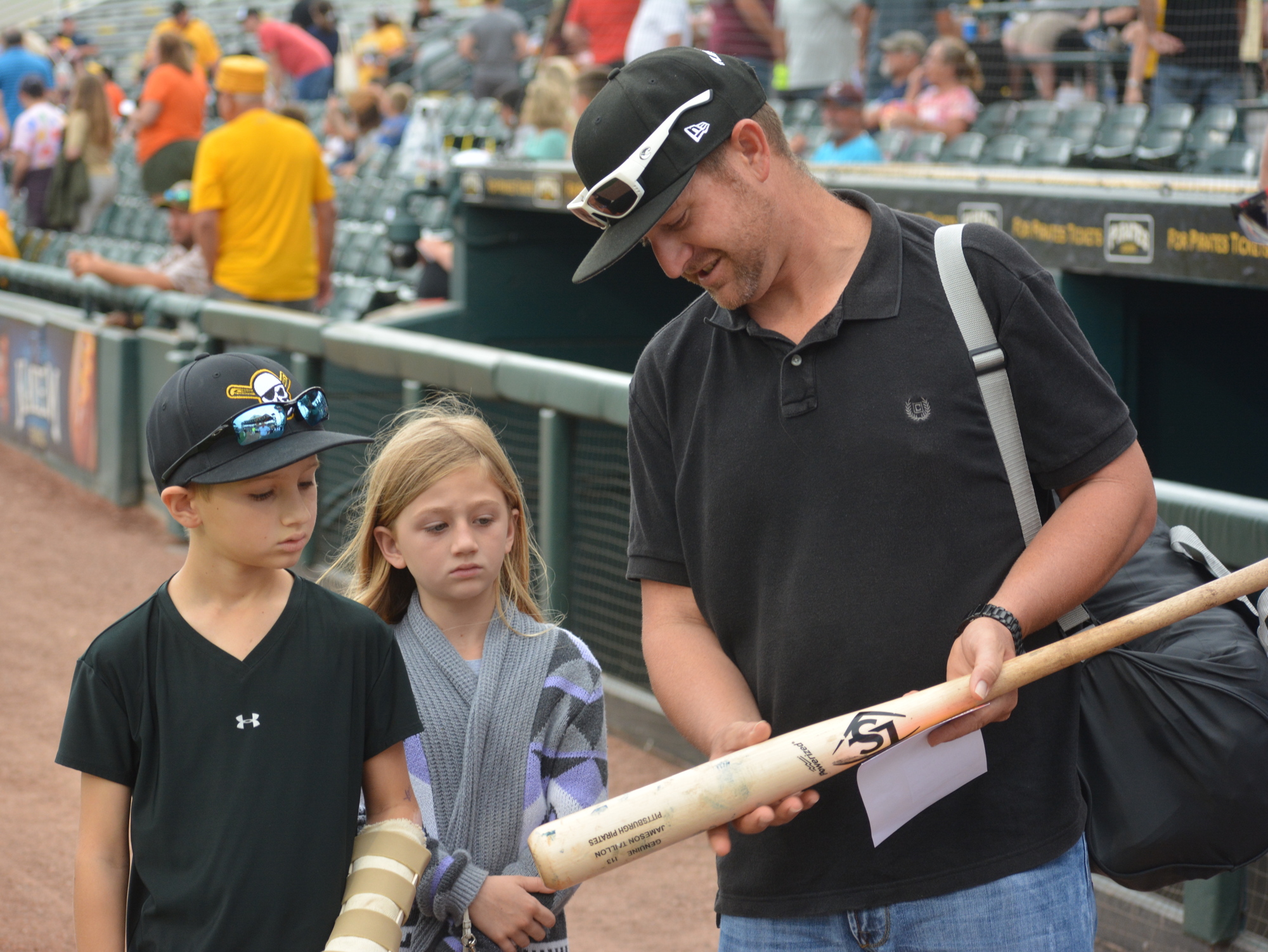 Landon, Camilla and Daryl Marazon check out a bat that was signed by the Marauders and given to Landon.