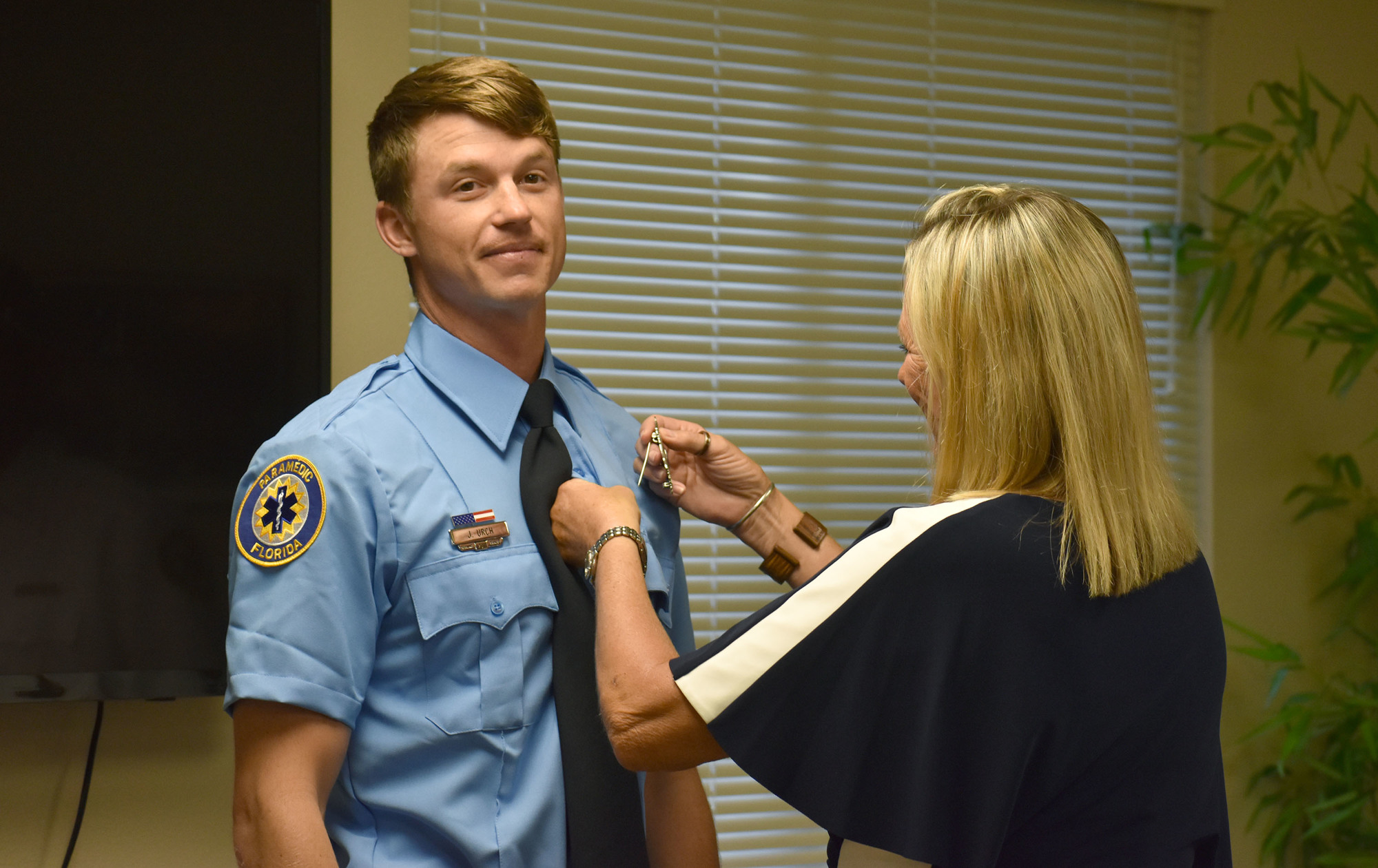 Kim Cavanagh, Urch's mother, pins his badge on his uniform.