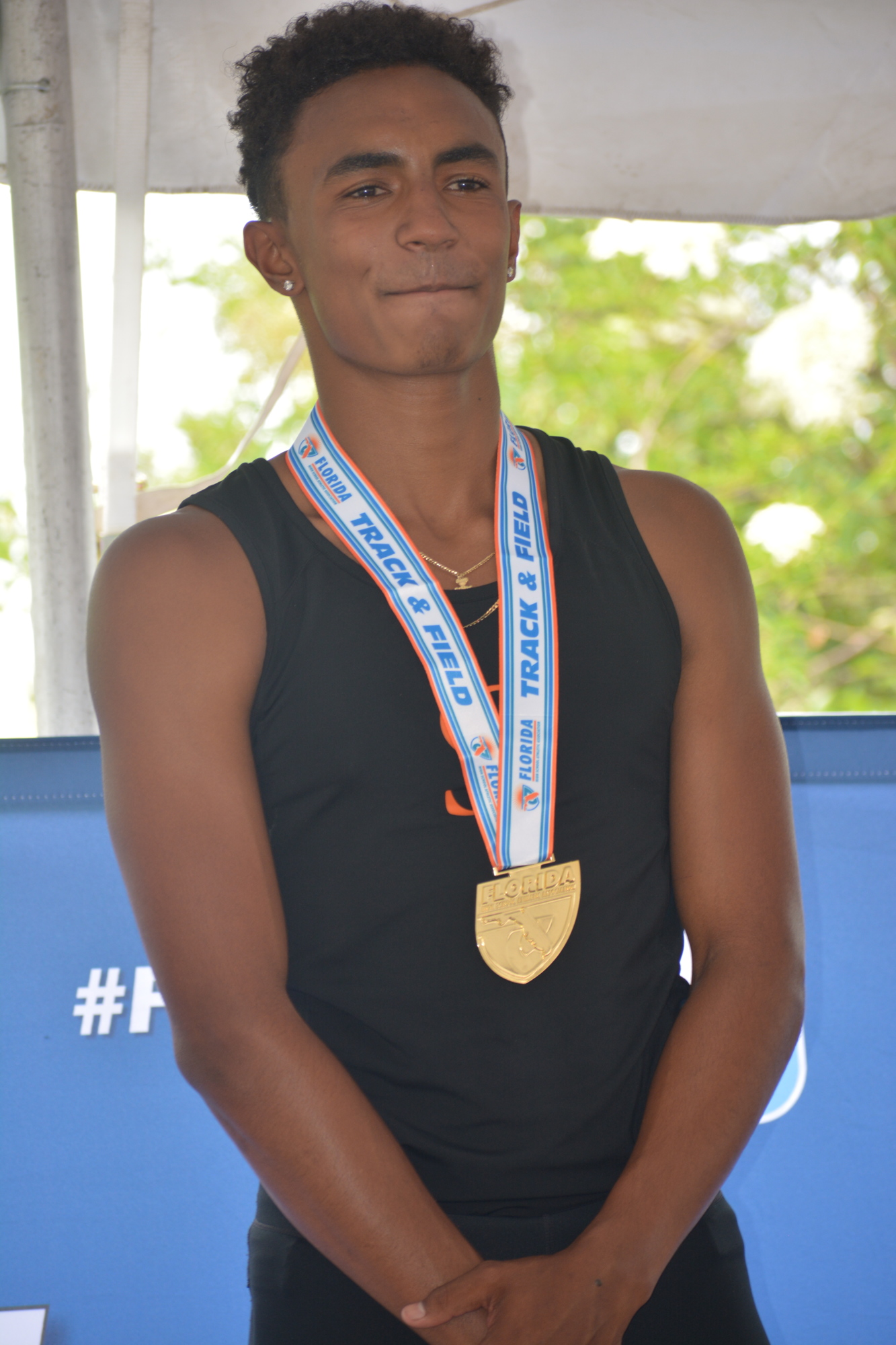 Jaasiel Torres flashed his gold medal after repeating as the Class 4A boys high jump champion at the Florida High School Athletic Association track and field championships at the University of North Florida in Jacksonville.