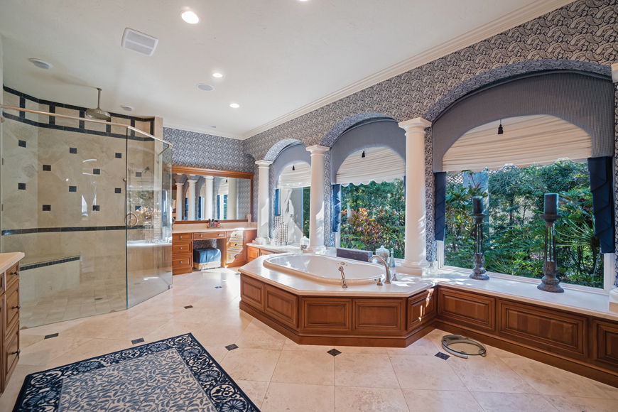 The spacious master bath offers a Jacuzzi tub plus a walk-in shower, and looks out into a private garden.