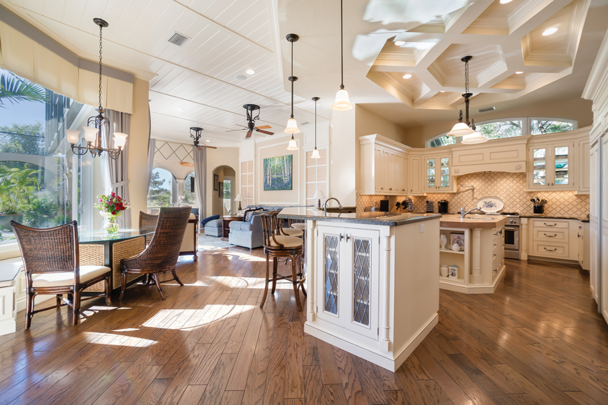 The open plan allows an easy flow for the home’s main floor. The kitchen and adjacent family room feature high ceilings and abundant natural light.
