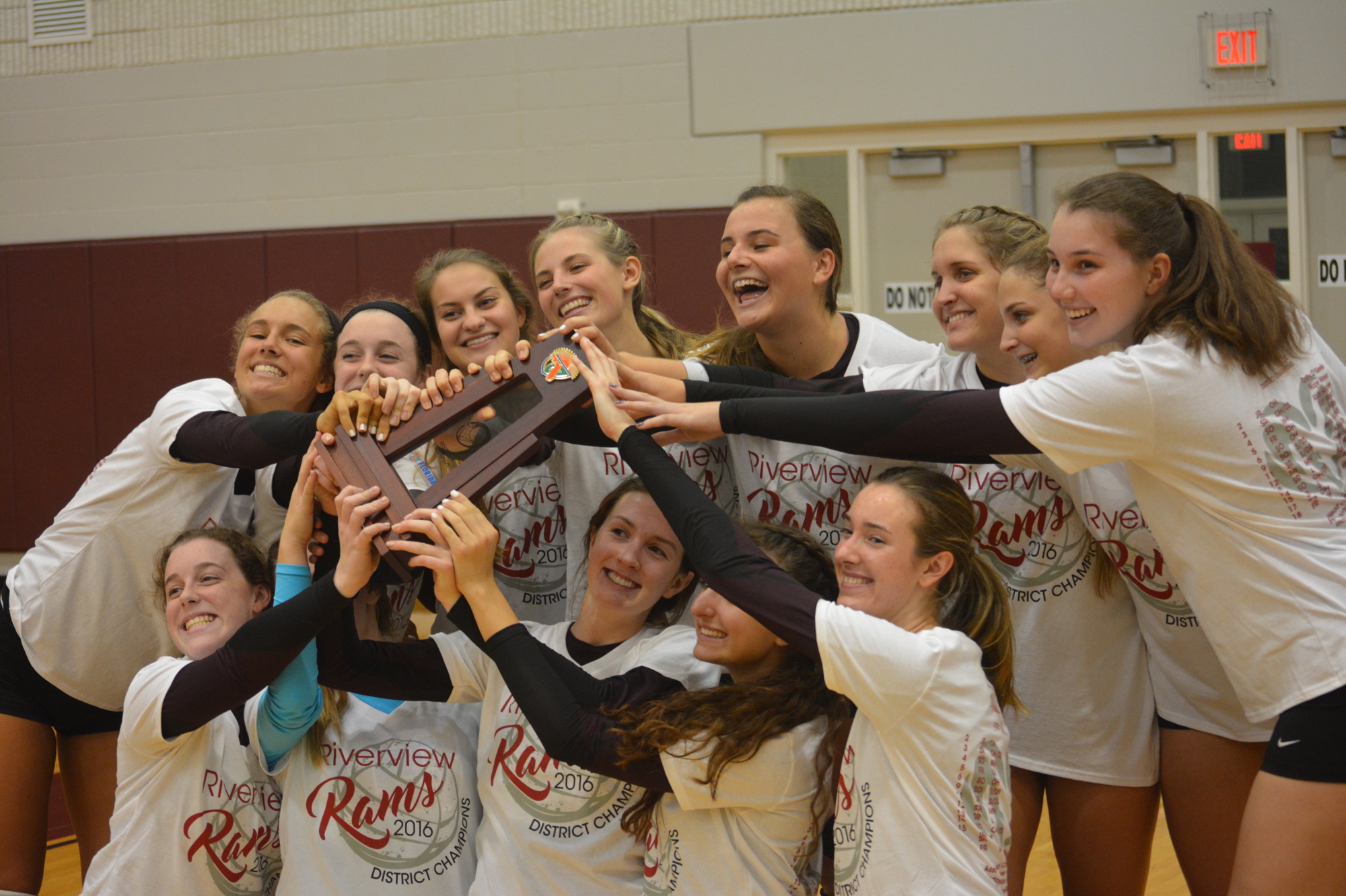 The Riverview volleyball team poses in its custom T-shirts with the district championship trophy.