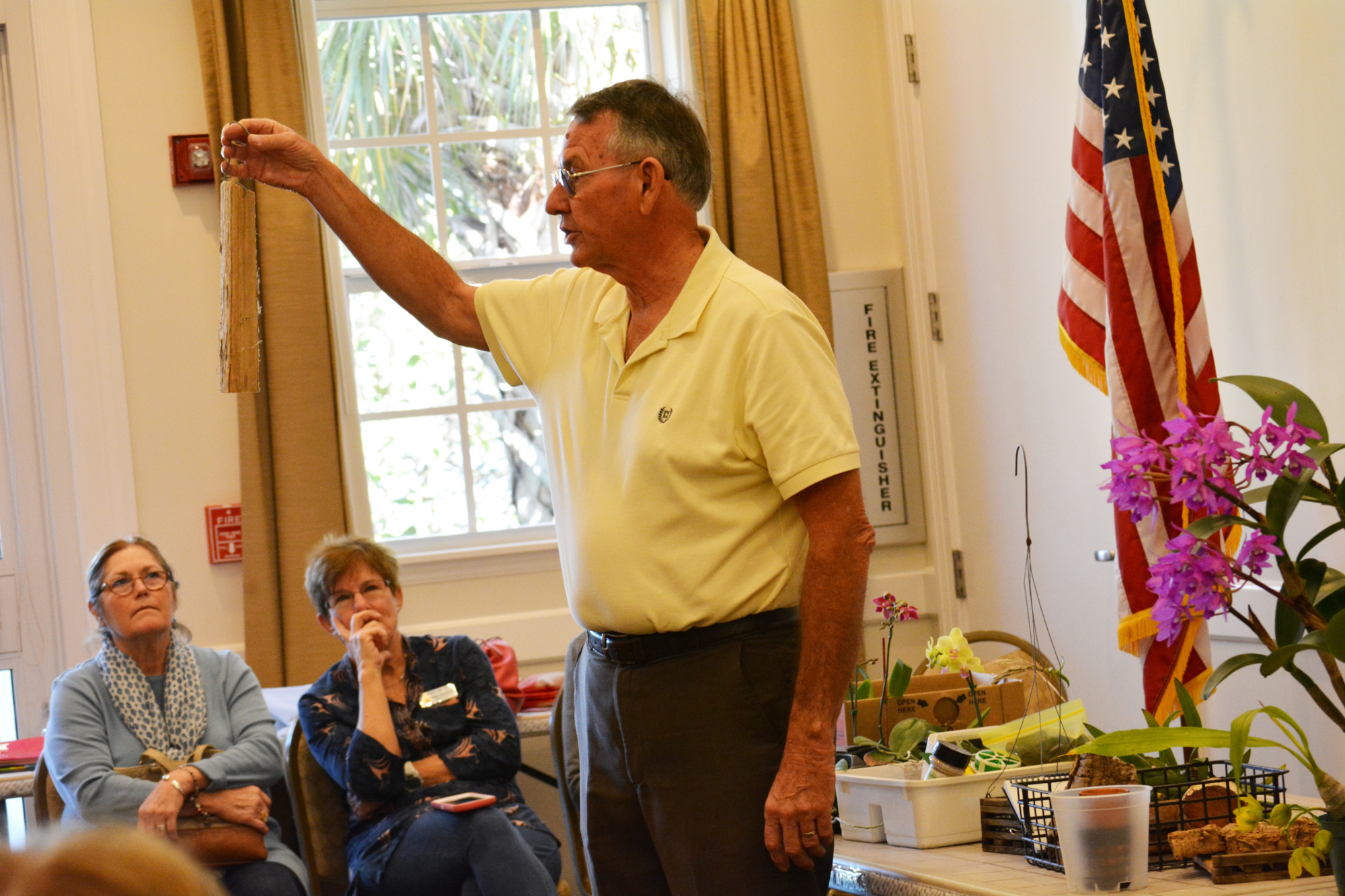 Roy Krueger, president of the Manatee Orchid Society, shows members and guests of the Lakewood Ranch Gardeners Out East Garden Club how to repot an orchid.