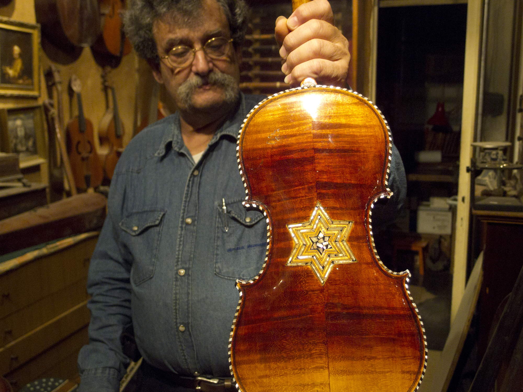 Amnon Weinstein restores violins with an emotional history. Photo by Debra Yasinow