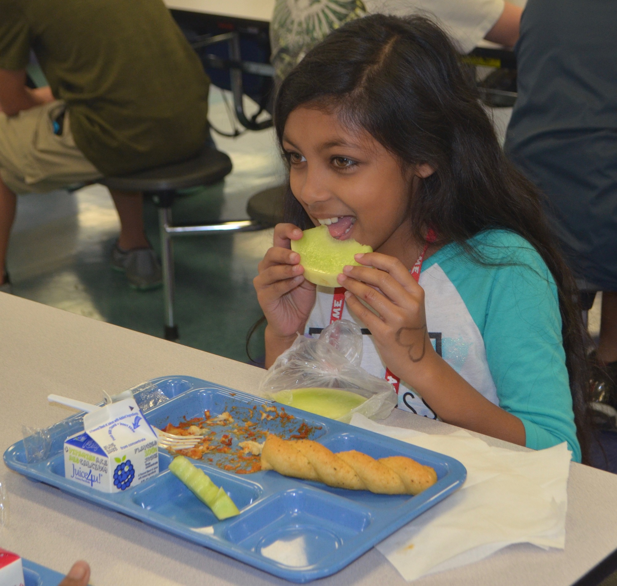 Karishma Dhountal, sixth grade at Haile, digs in to her honeydew during lunch in the cafeteria.