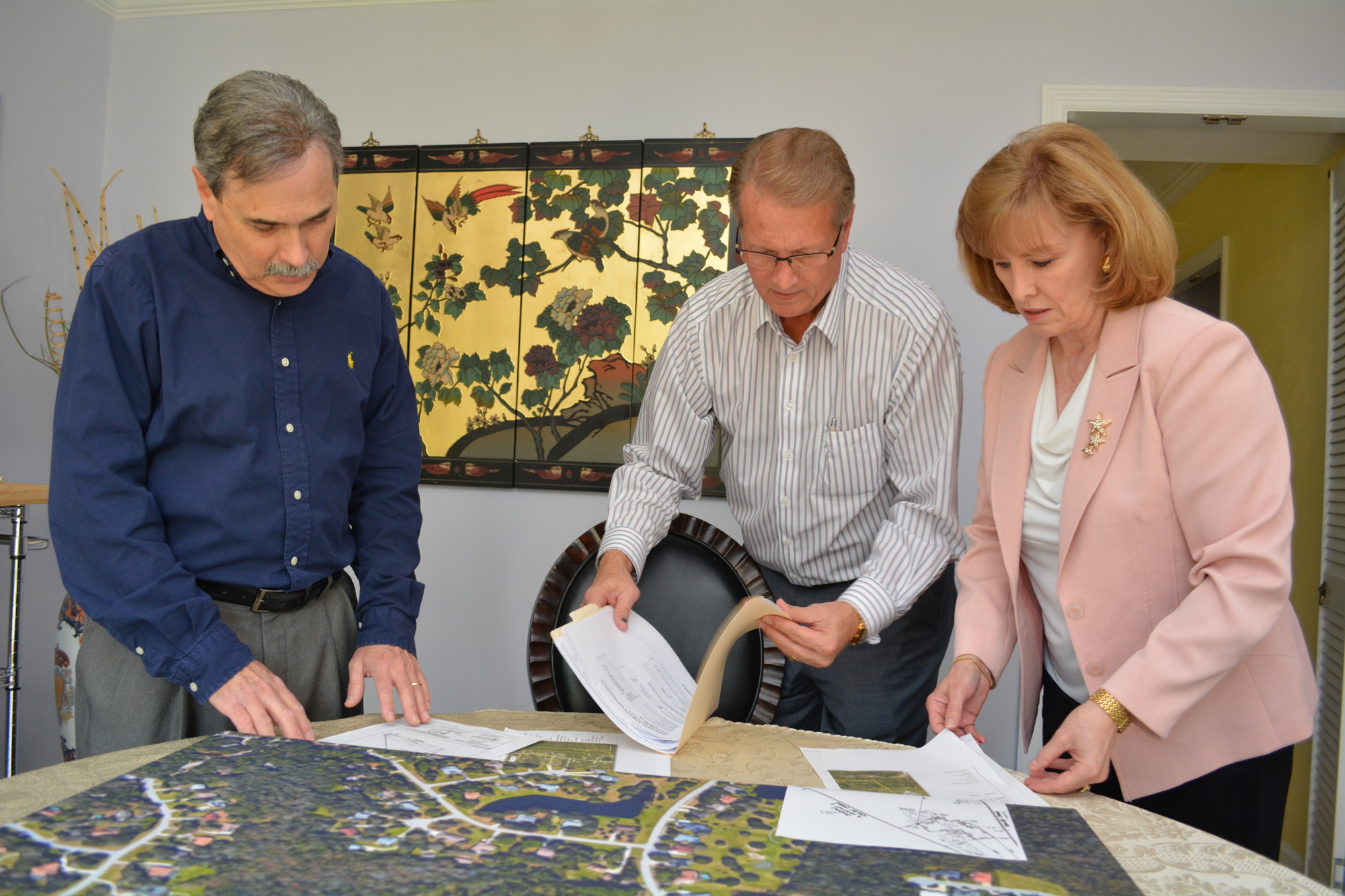 Friends of Keep Woods founders Gary Herbert, Phil St. John and Brenda Russell, all residents of Braden Woods, review documents and maps regarding the property in question. They are pursuing multiple avenues for preserving the land