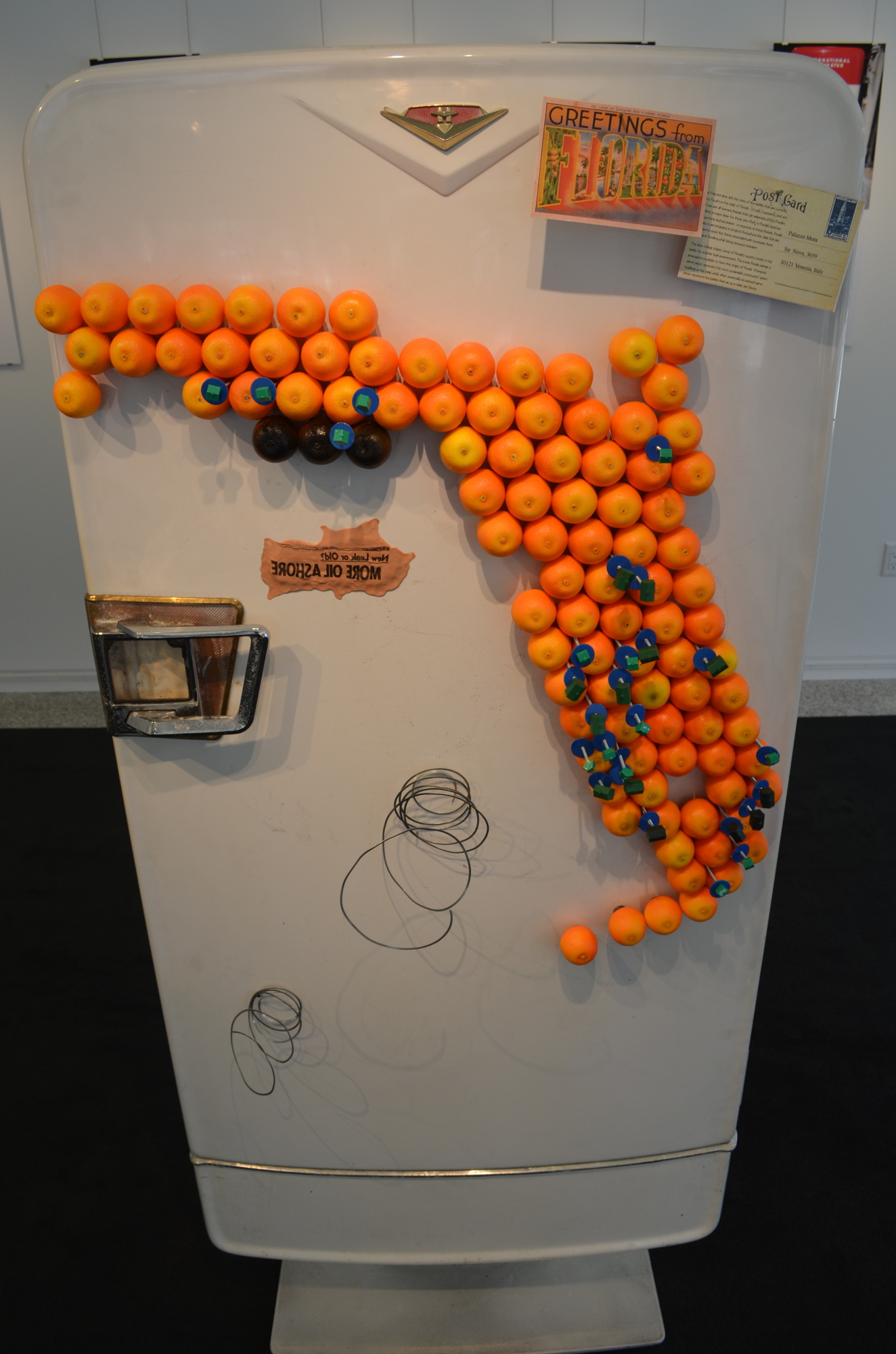 Todd Sweet’s door features oranges arranged in the shape of Florida, with black colors representing oil spills, coils depicting hurricanes and plastic houses showing environmentally sustainable structures.
