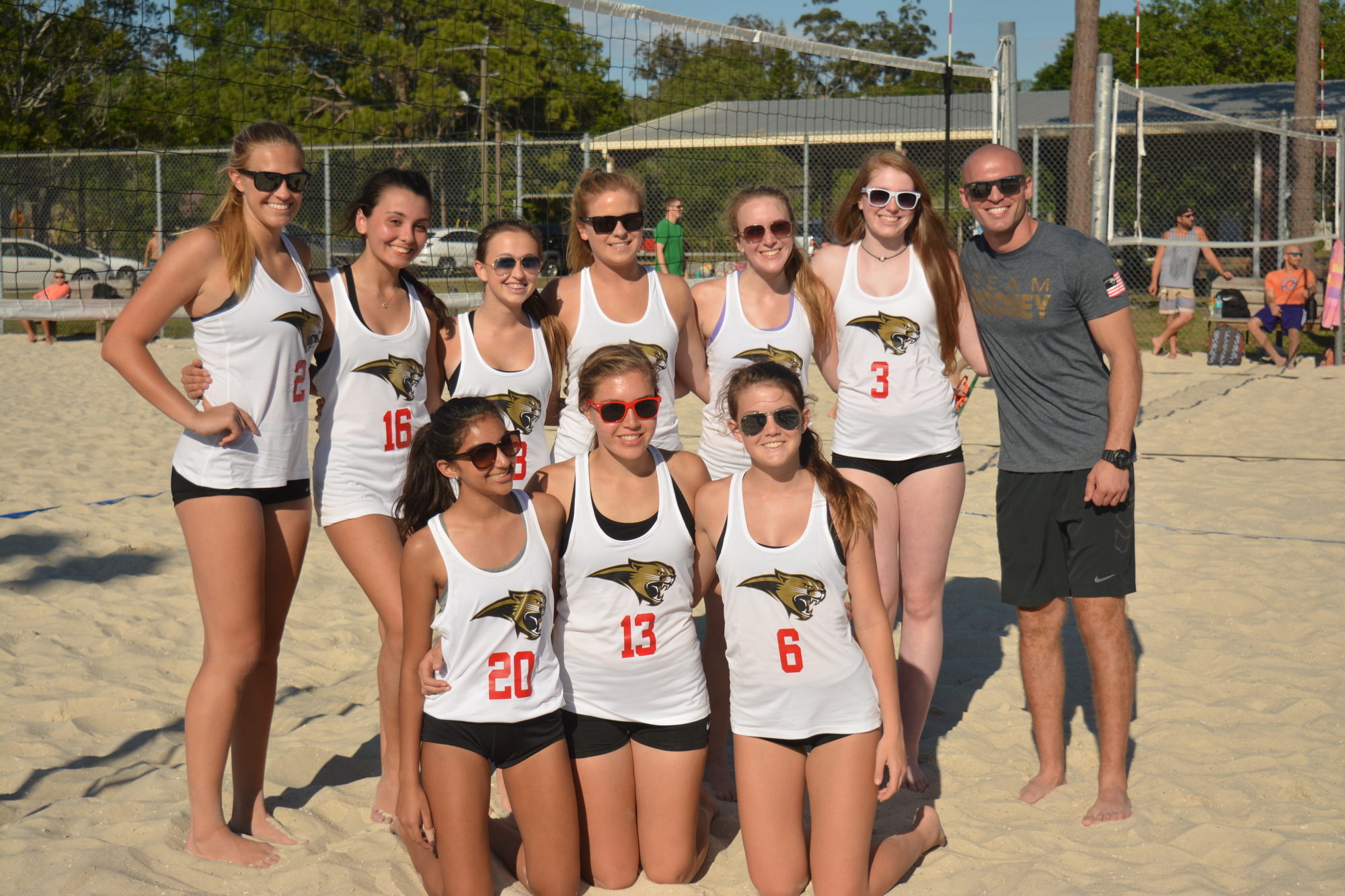 Chad Sutton (right) poses with his Cardinal Mooney beach volleyball team. Sutton also coaches indoor volleyball for the Cougars.