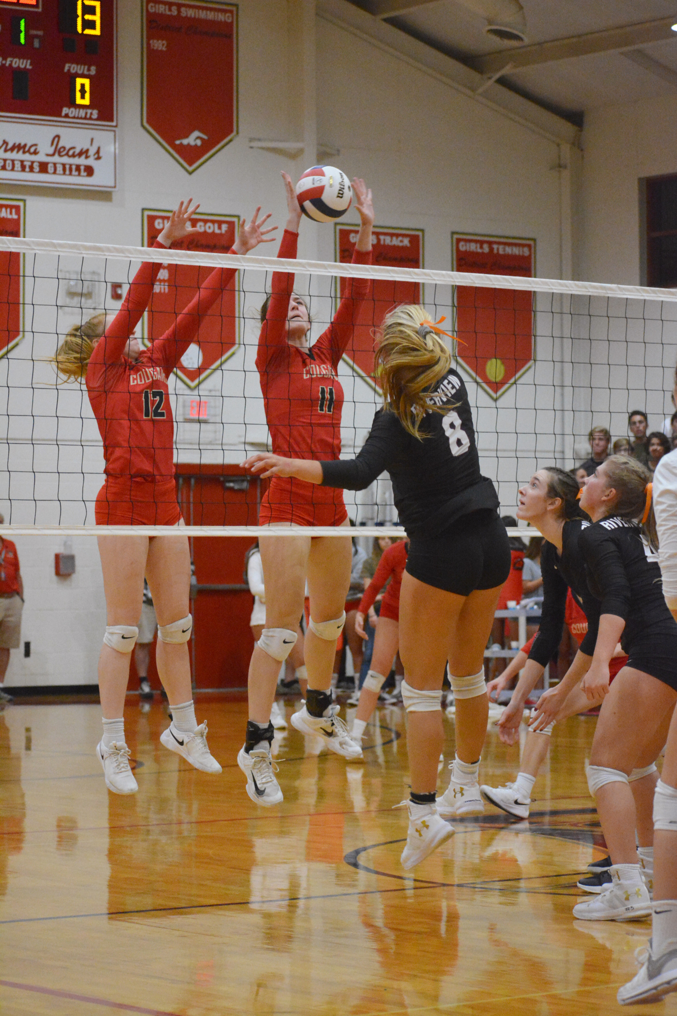Junior Anna Klemeyer (11) gets a block on a Riverview player's kill attempt.