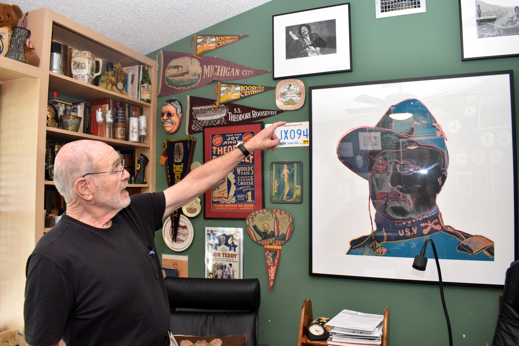 Andy Maass points to a Warhol inspired painting of Theodore Roosevelt.