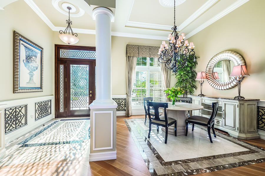 A custom glass front door, both leaded and beveled, welcomes guests. The formal dining room is to the right.