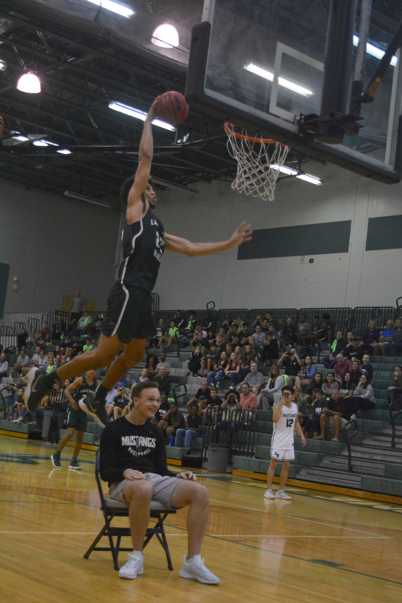 Boys junior Christian Shaneyfelt leaps over student assistant coach Brady Roberts during the dunk contest.
