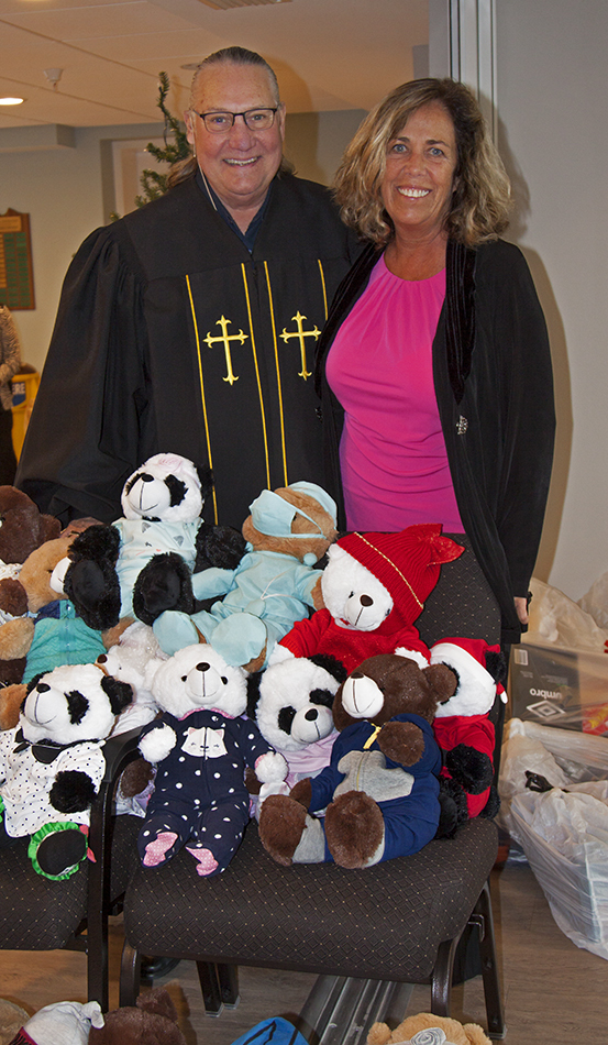 The Rev. Bill Friederich and Bah Hero pose with the bears that were dressed by members for the Salvation Army.