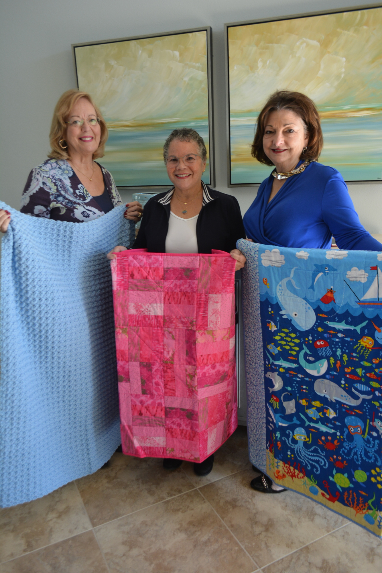 Ann Sledz, Miriam Echevarria and Eileen Buzzard  show off the blankets for charity.