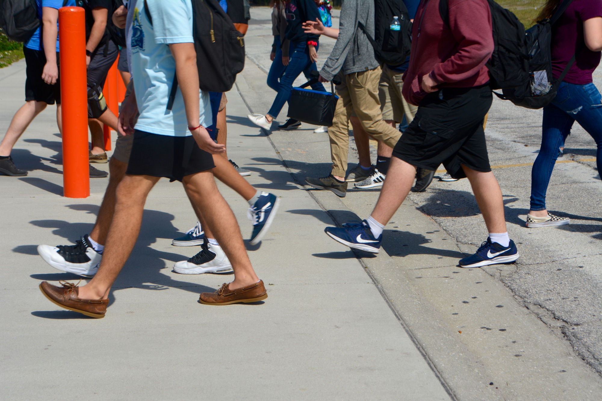Sarasota High School students cross School Avenue, which bisects their campus.