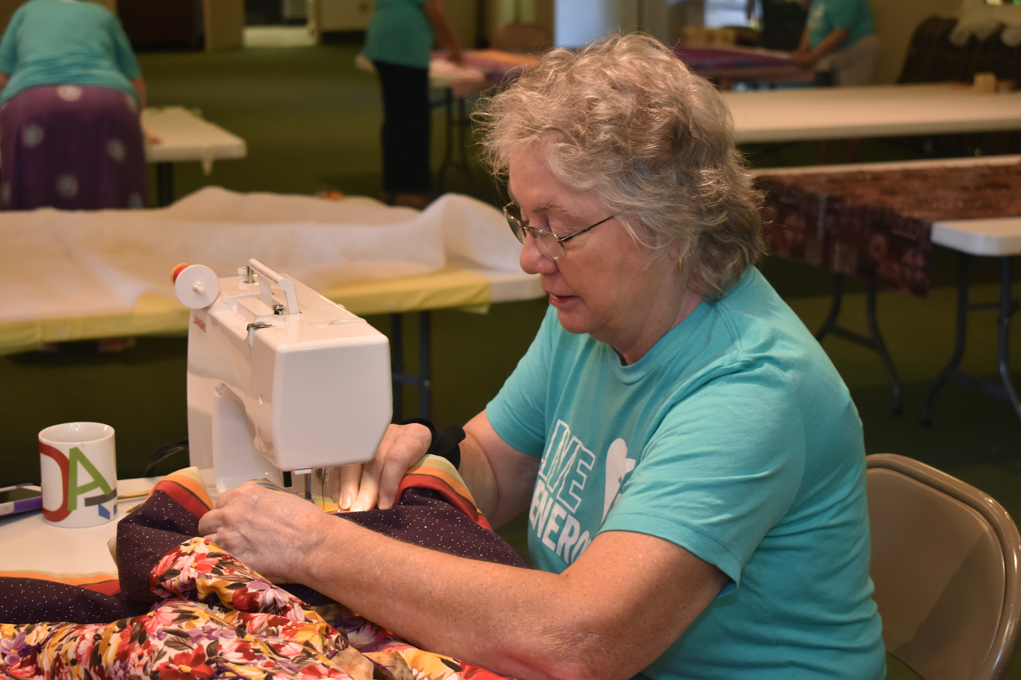 Nona Arnholt sews the finishing touches of a quilt.