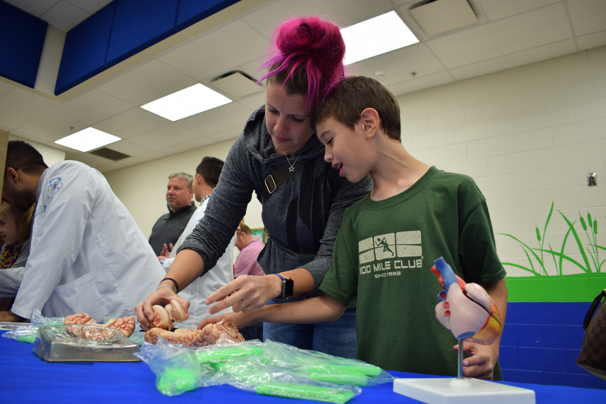 Sasha Corbo and her son, second-grader Benjamin, work with a replica of a brain brought by LECOM.