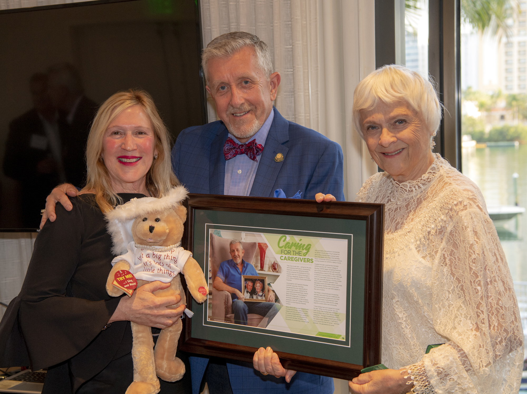 Joann Schoenbaum Miller, Phil King and Karen Holbrook hold a framed article referencing Phil’s estate gift and which shares a picture of Phil and Betty. Photo by Cliff Roles.