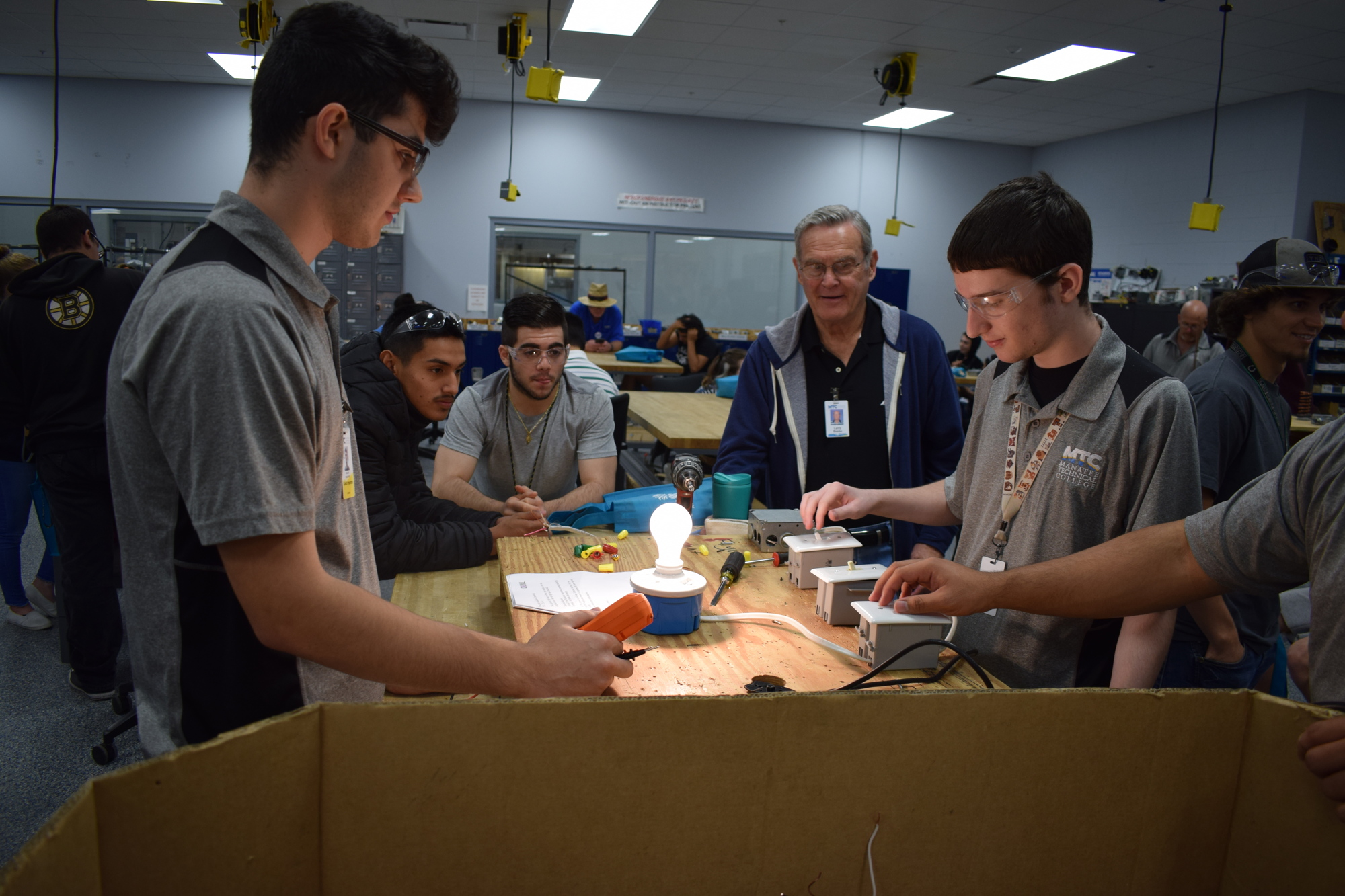 Lakewood Ranch High School students and MTC students look at a project that's been wired and electrified.