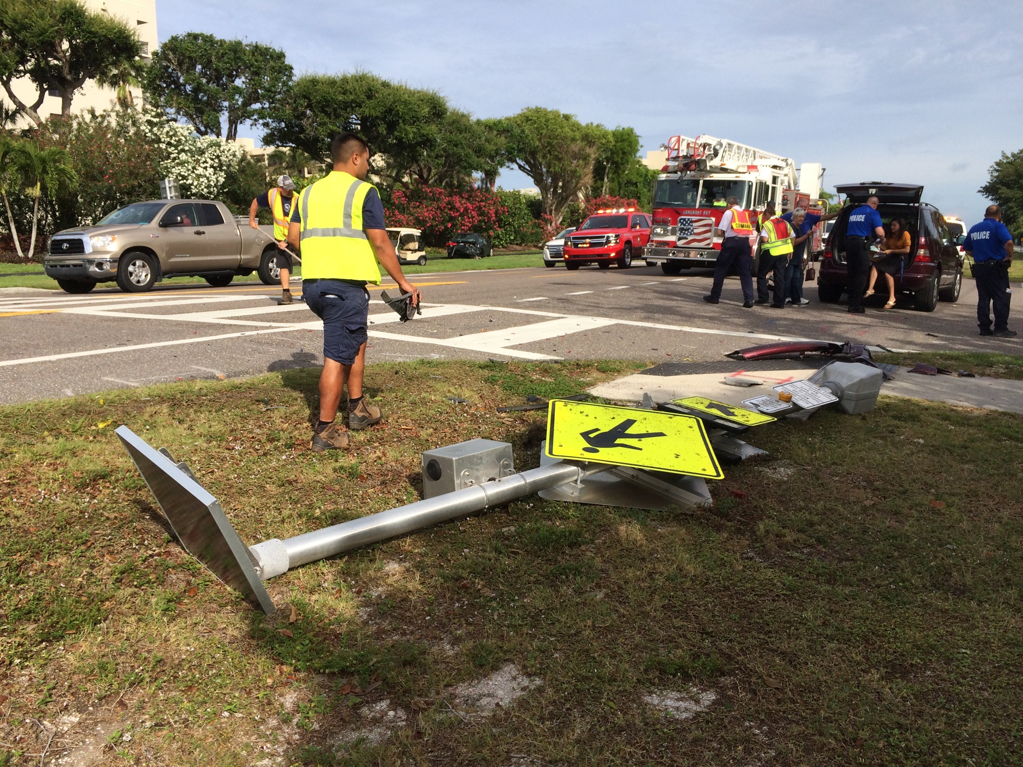 One of the cars collided with the crosswalk sign, knocking it over. 
