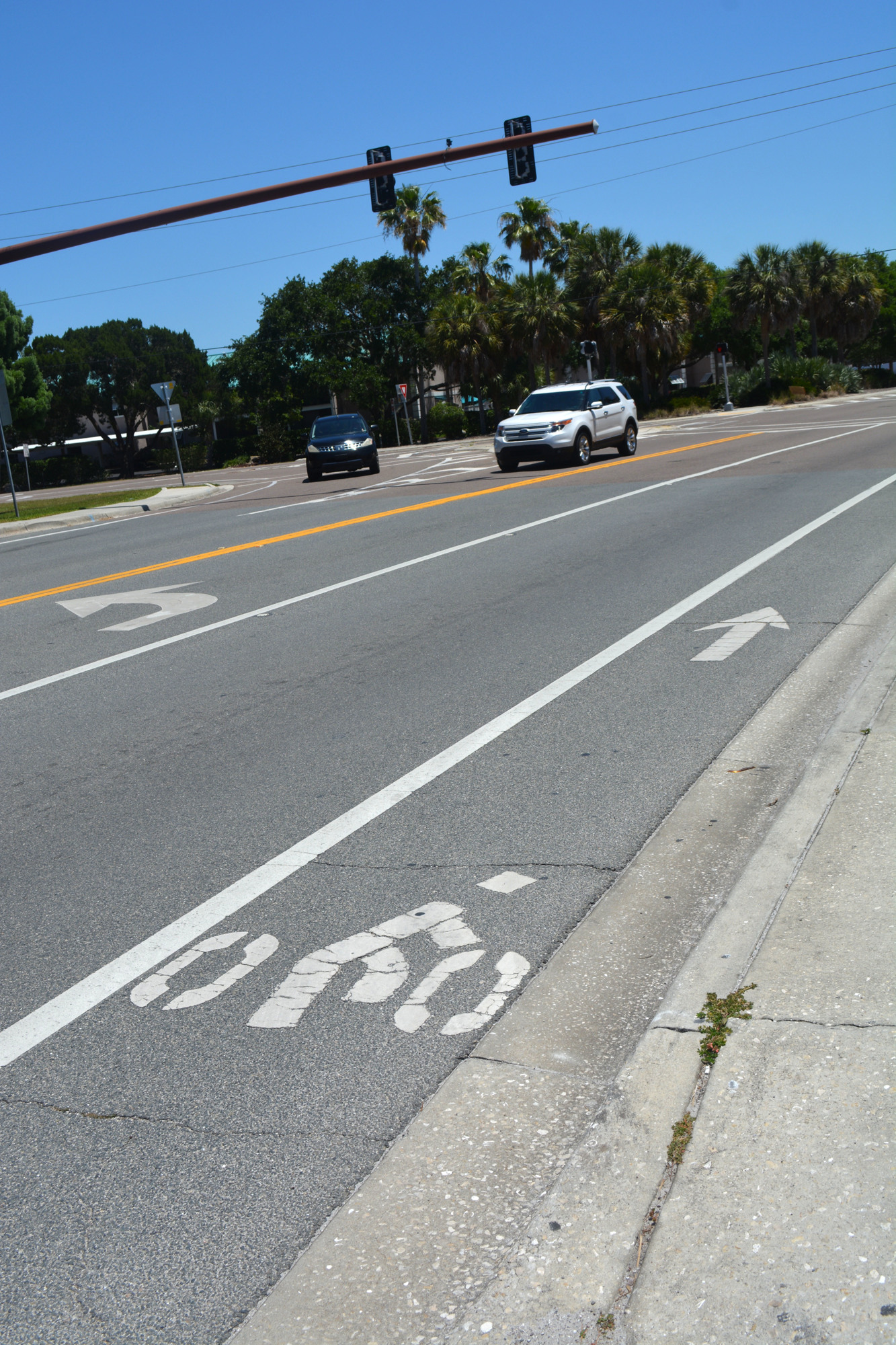According to AASTHO, bike lanes should be painted with the image of a cyclist and an arrow that points in the proper direction. The bike lanes on Midnight Pass largely lack such paint. This one can be seen on Beach Road.