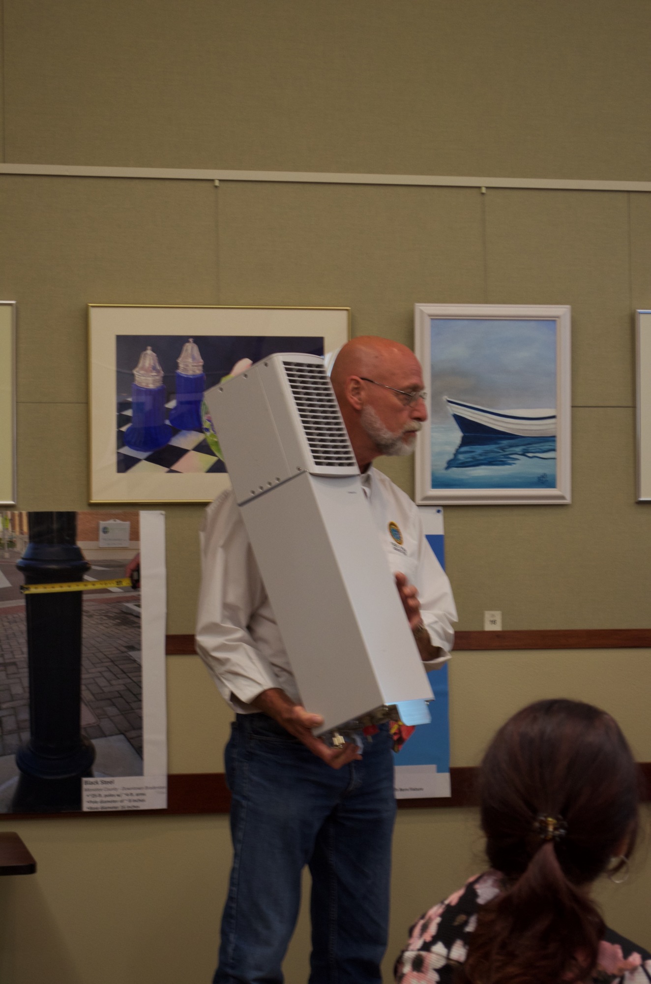 James Linkogle shows commissioners a small-cell transmission device that can be used by four carriers. The so-called backpack can be attached to the backside of a light pole and painted to match.