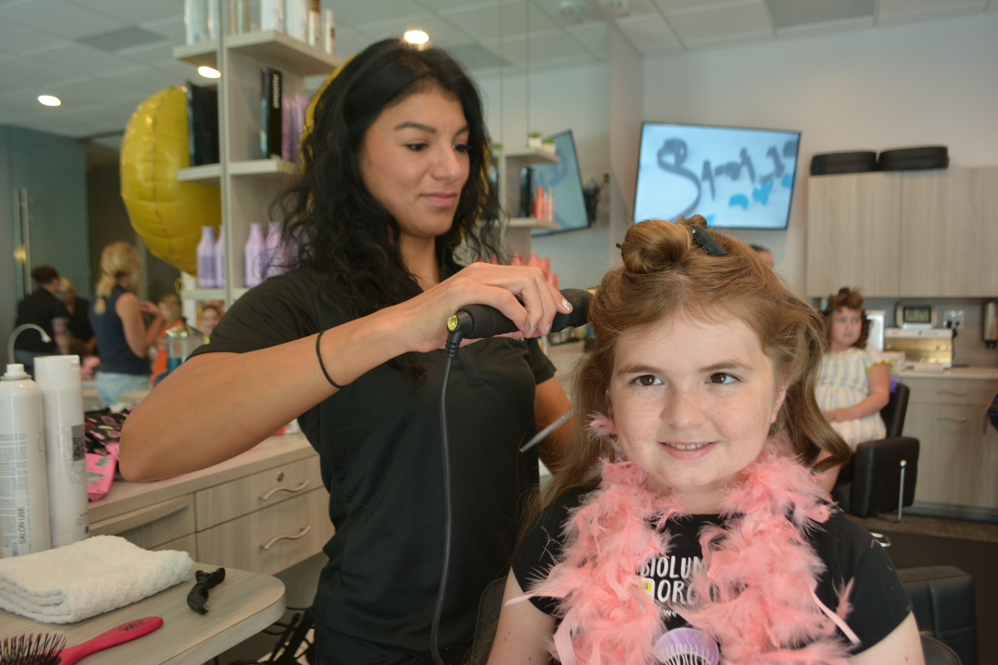 Cosmetologist Ester Arnsby curls of hair of Sarasota 15-year-old Valerie Welch.