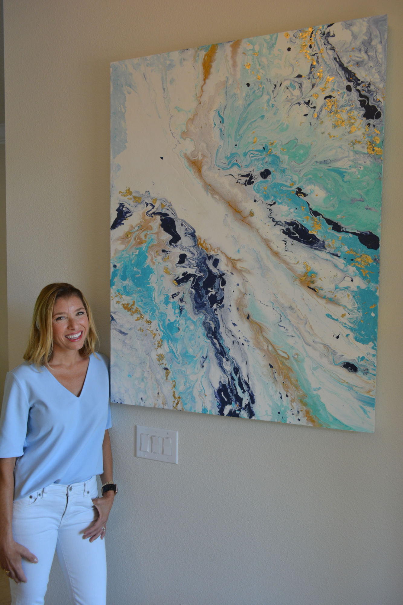 Mill Creek's Kori Clark stands with one of her flow paintings.