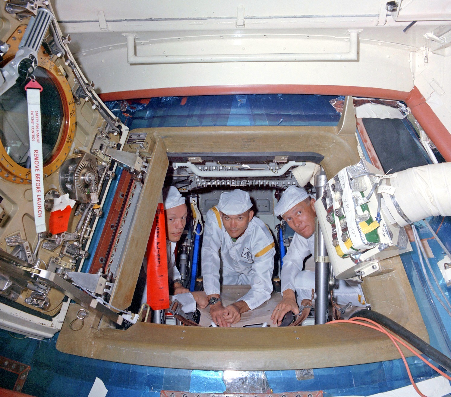 The Apollo 11 crew aboard their command module atop the Saturn V on June 10, 1969. Armstrong, Collins and Aldrin are wearing protective coveralls as they perform a 