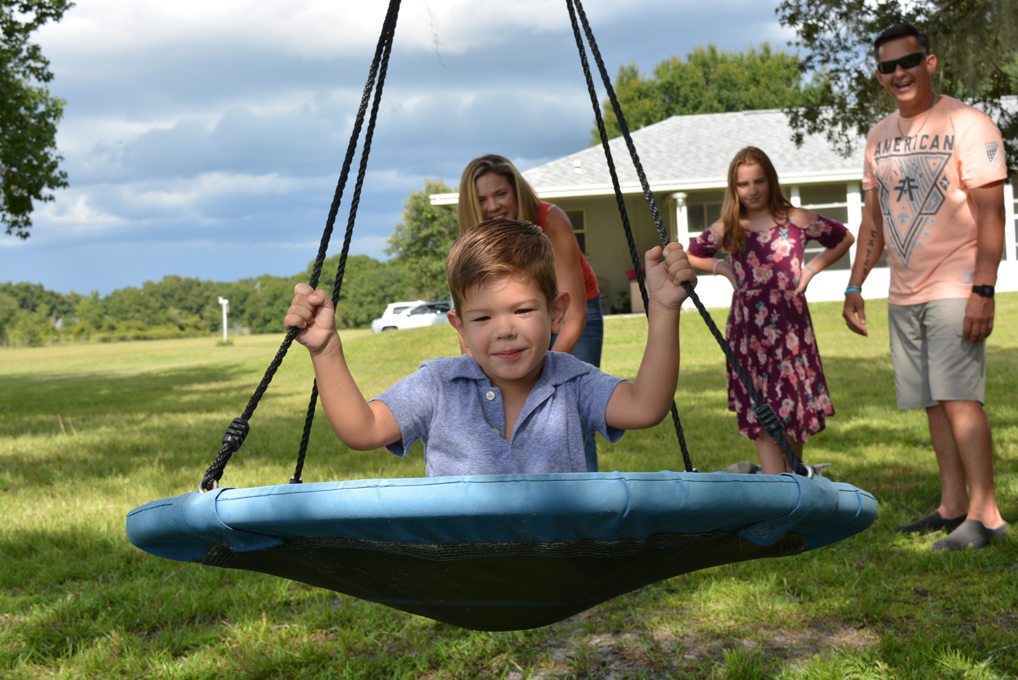 Colton Lawson, 3, loves the swing in his backyard. He prefers to ride it without his prosthetic legs. His parents, April Costello and Chris Lawson, and sister, Taylor Lawson, watch Colton swing with glee.