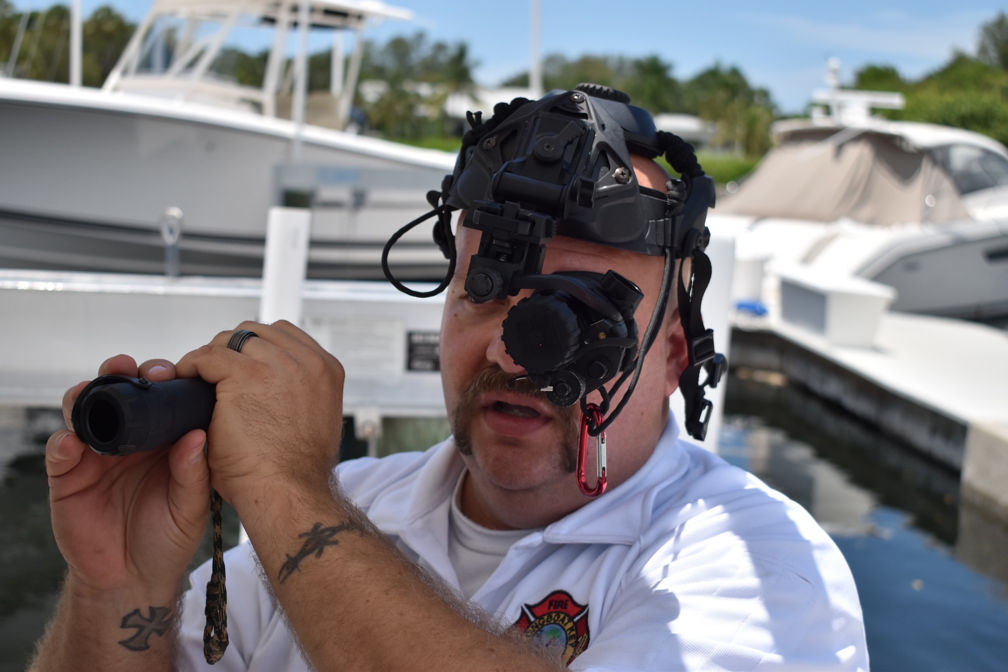 Lieutenant Brandon Desch wears the night vision monocular and holds in the infrared torch.