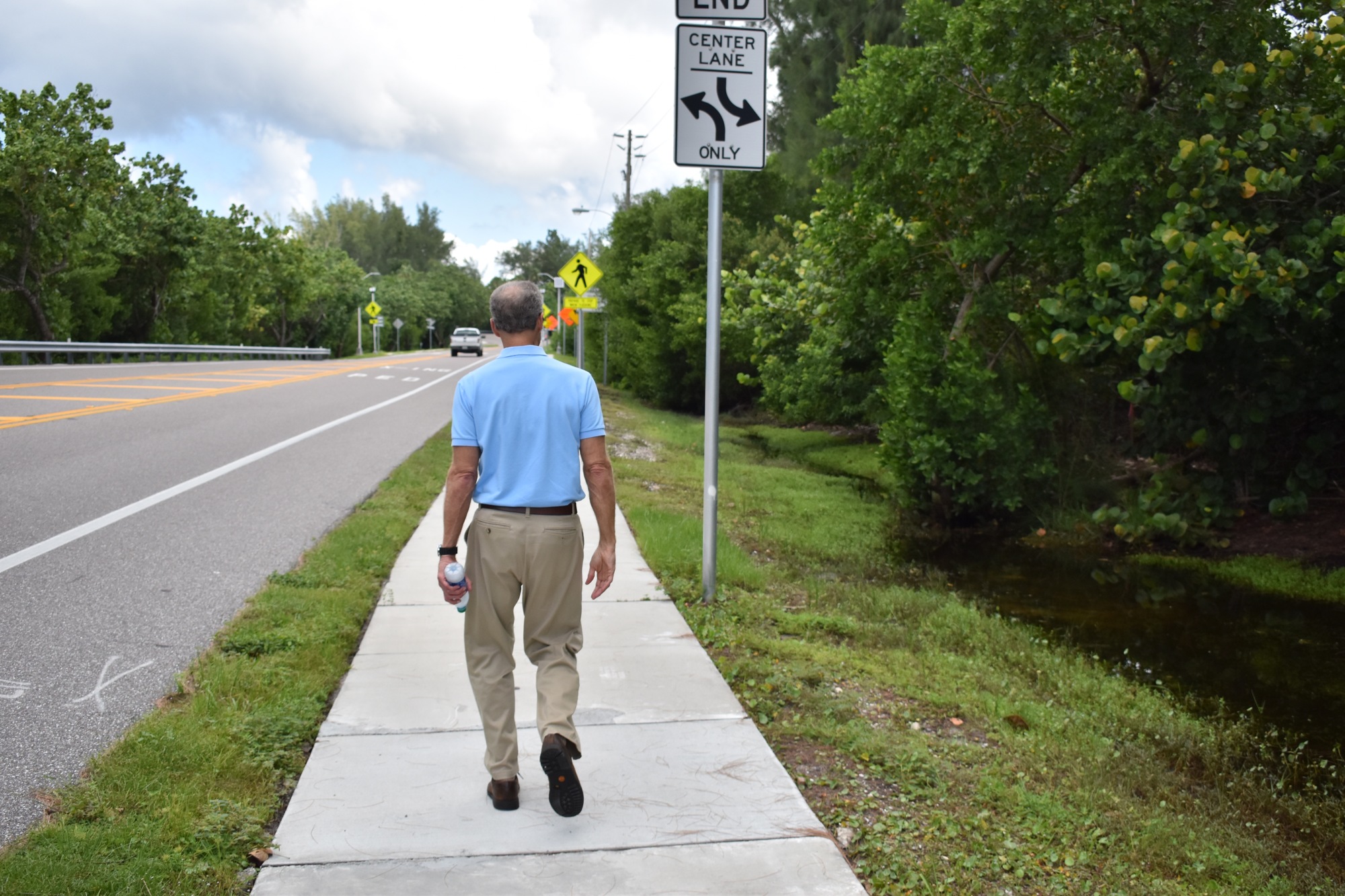 Bill Saba walks along Gulf of Mexico Drive adjacent to a section of land purchased from him and his sister by five different parties.
