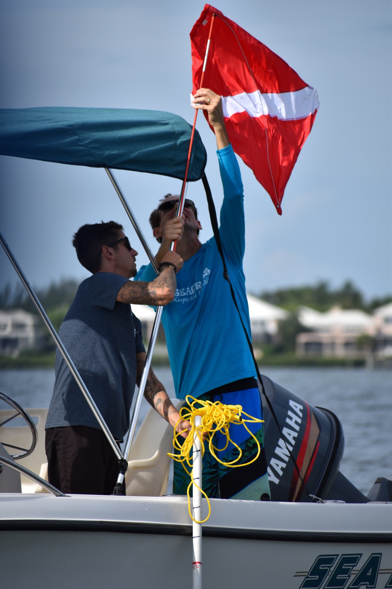Nate Falcone and Peter Peduzzi raise the diver-down flag before snorklers went into Sarasota Bay just east of Longboat Key.