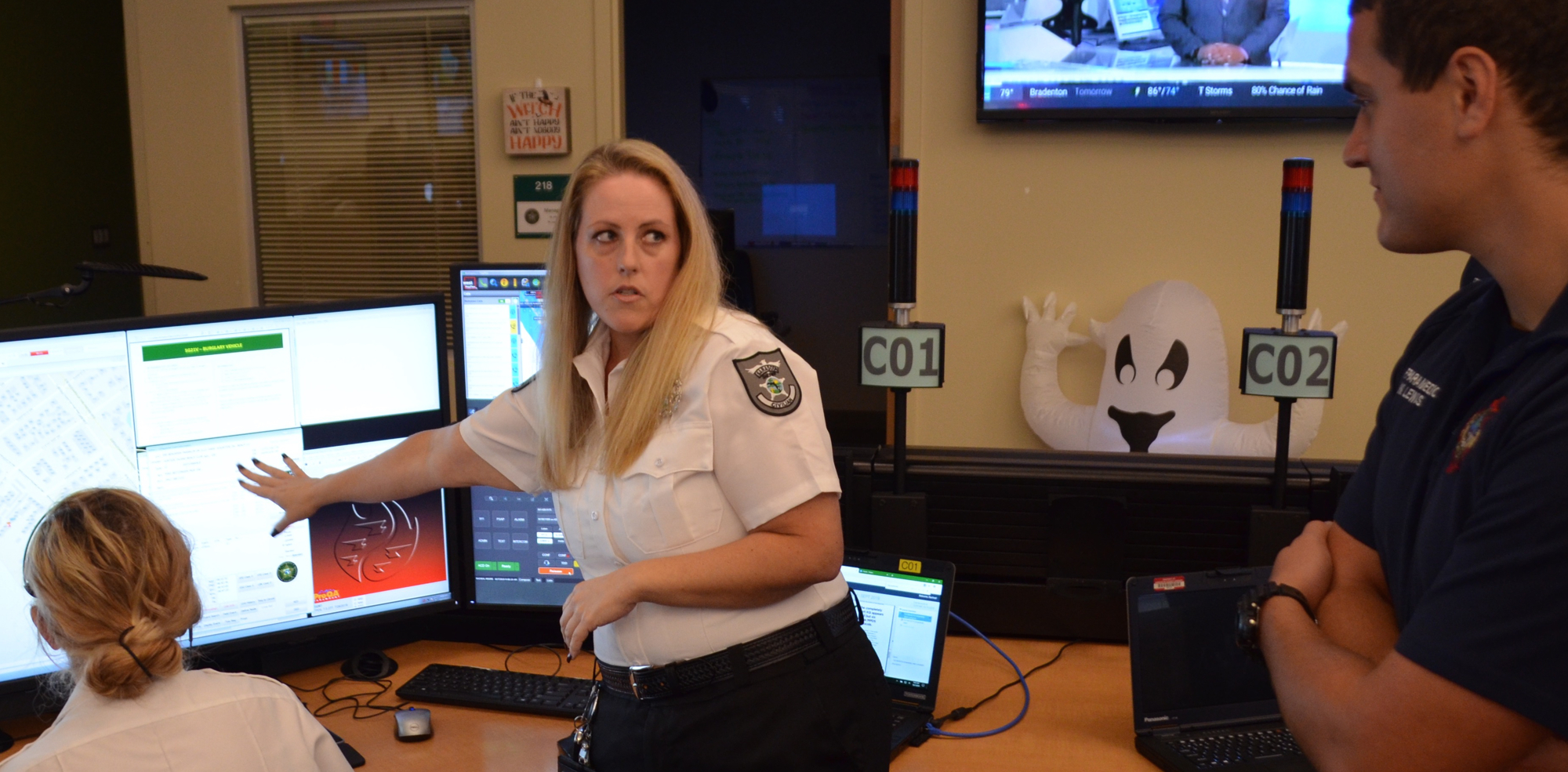Operations Manager Kristen Fitzpatrick explains one of the call takers' displays to firefighters.