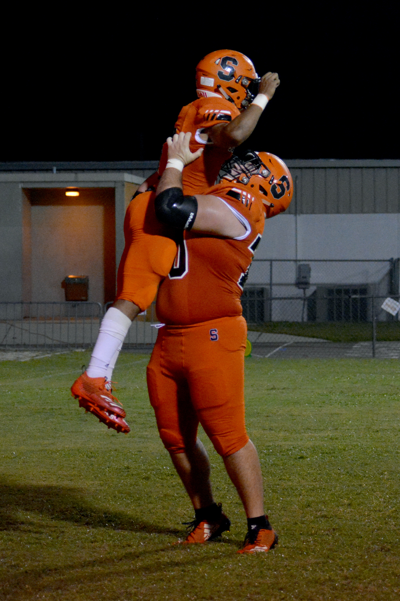 Sailors senior running back Brian Battie is hoisted in the air by senior guard Mac Mitchell after a touchdown.