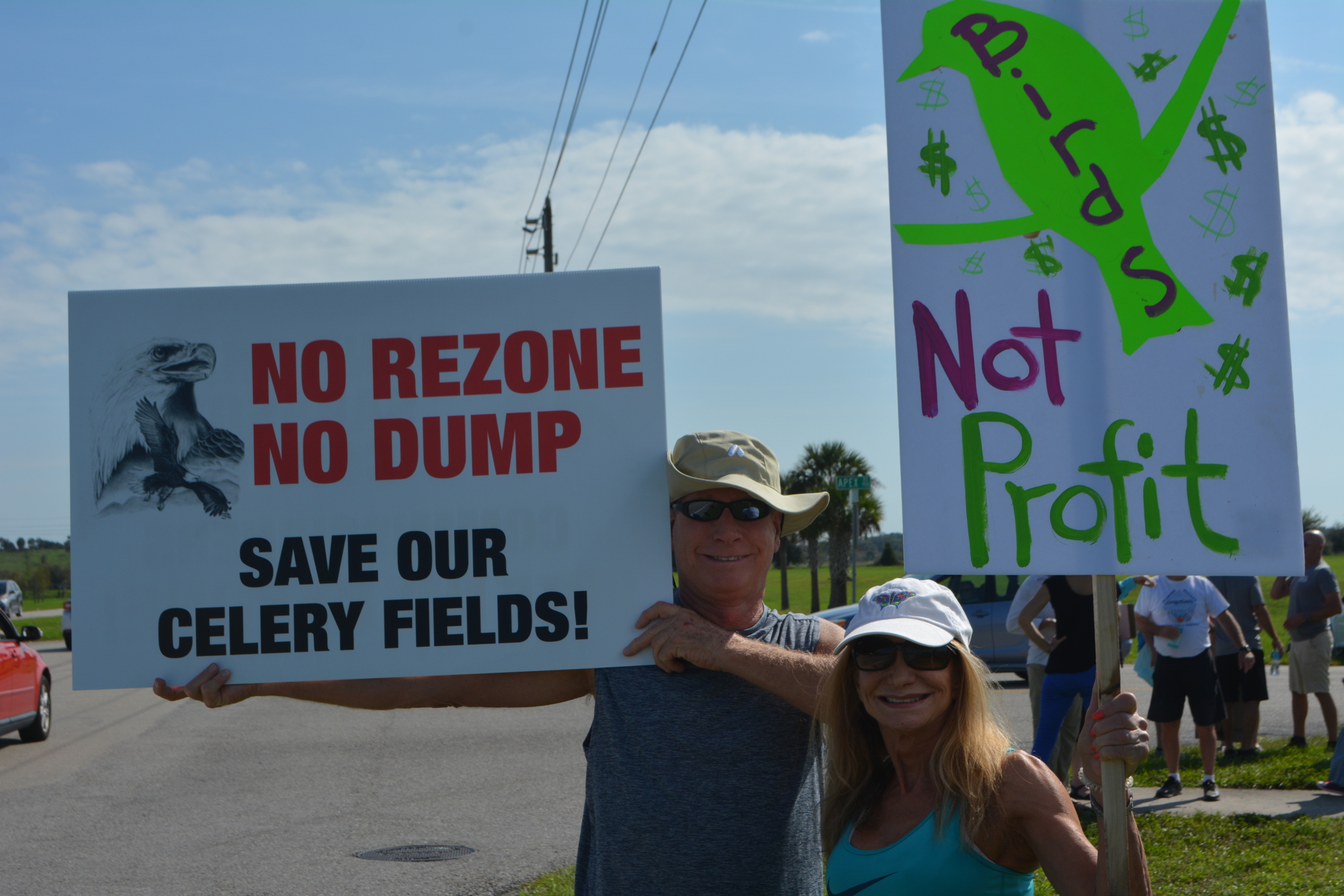 John Berry (left) and Carol Scholl stand by Palmer Boulevard to protest potential development of the Quads. Plans for the land will be discussed in a public Sarasota County Commission meeting at 1:30 p.m. Wednesday.