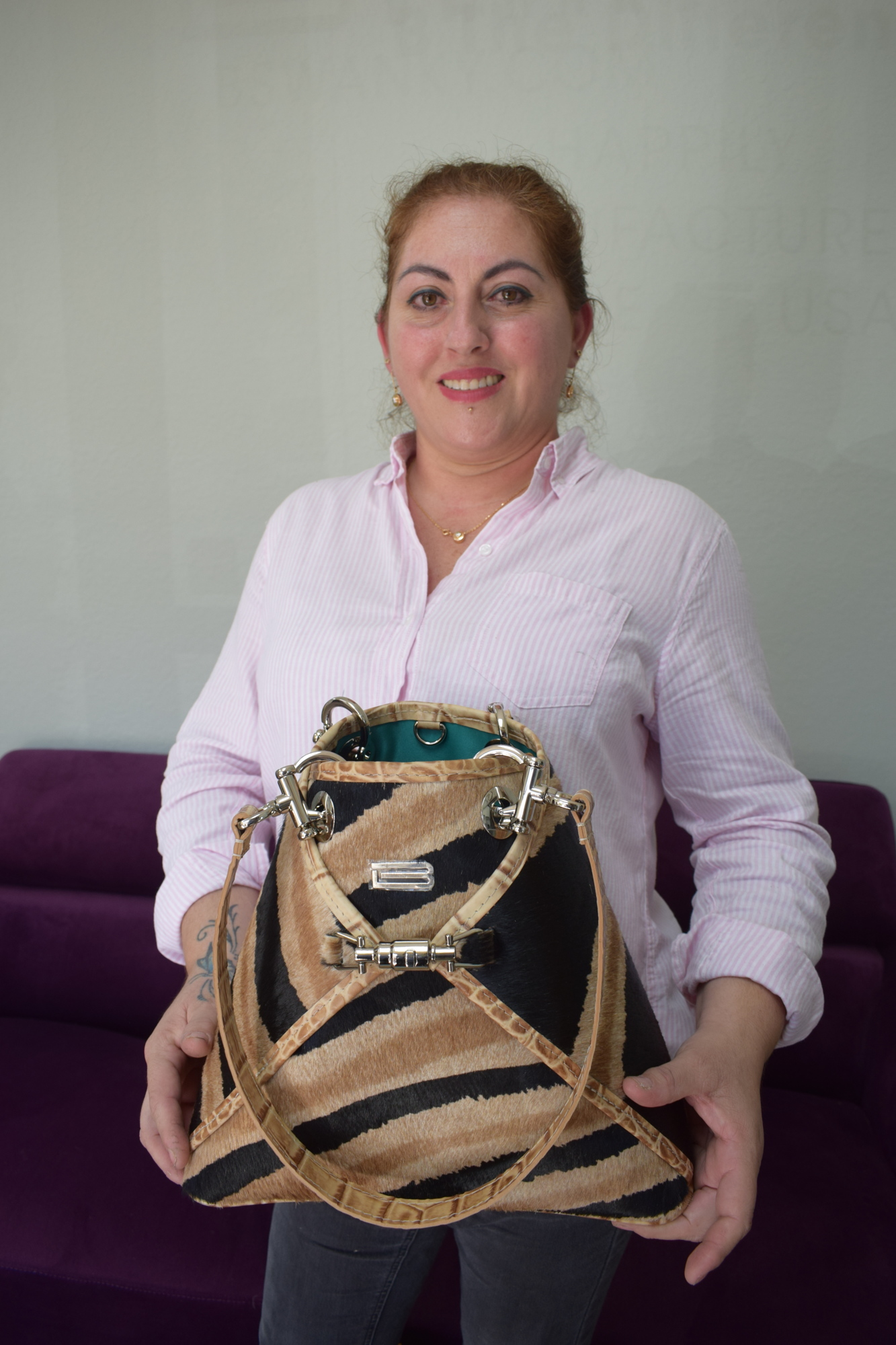 Kathy Reategui holds one of her favorite BSwanky designer handbags she helped to create.