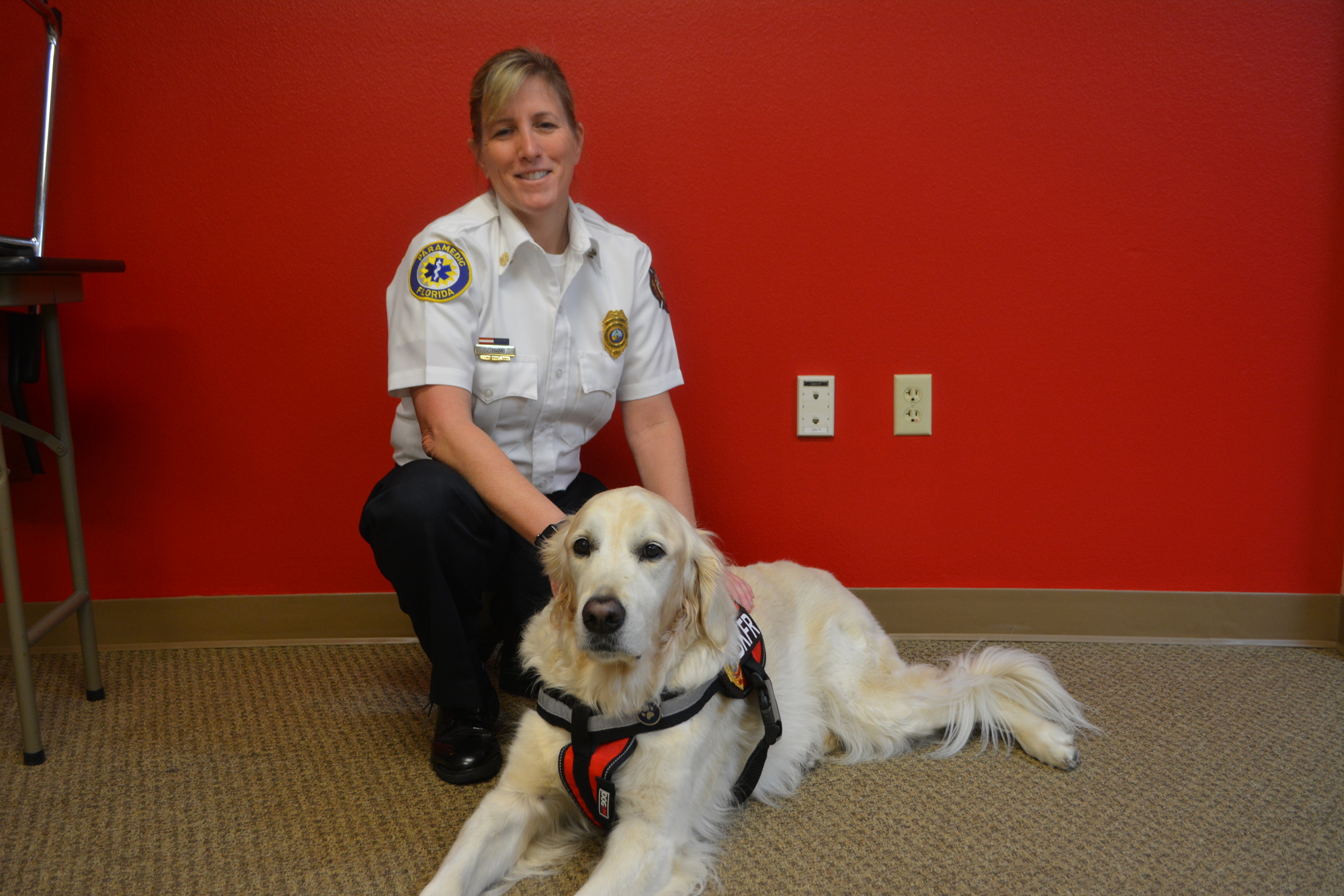 Hunter lies down next to his owner, Longboat Key Fire Rescue Department Deputy Chief Sandi Drake.