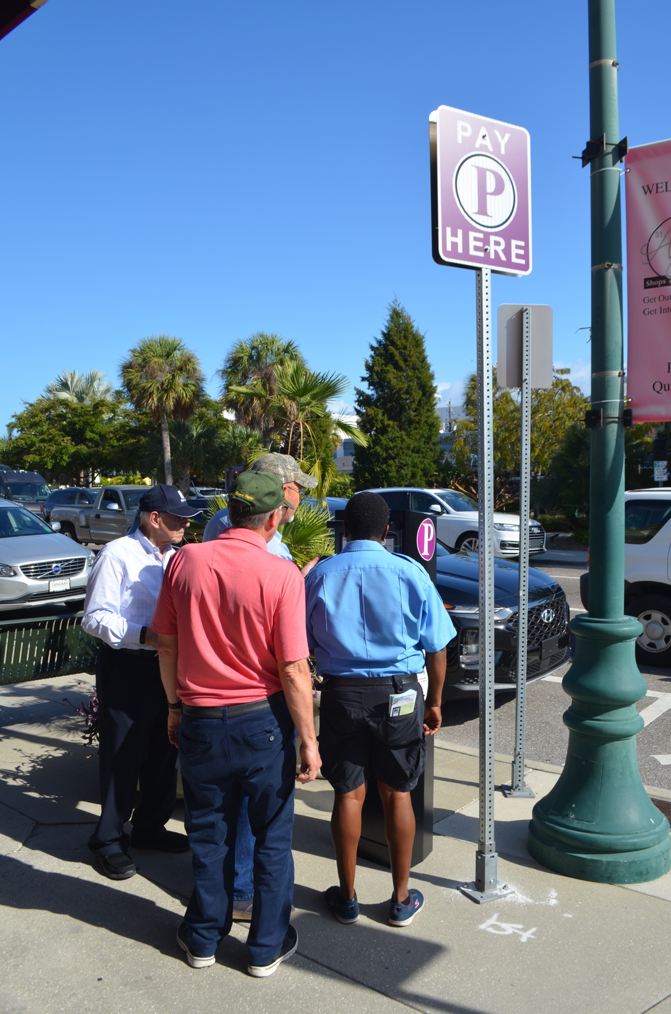 Potential parkers examine a kiosk with the help of a Sarasota staffer in St. Armands Circle.