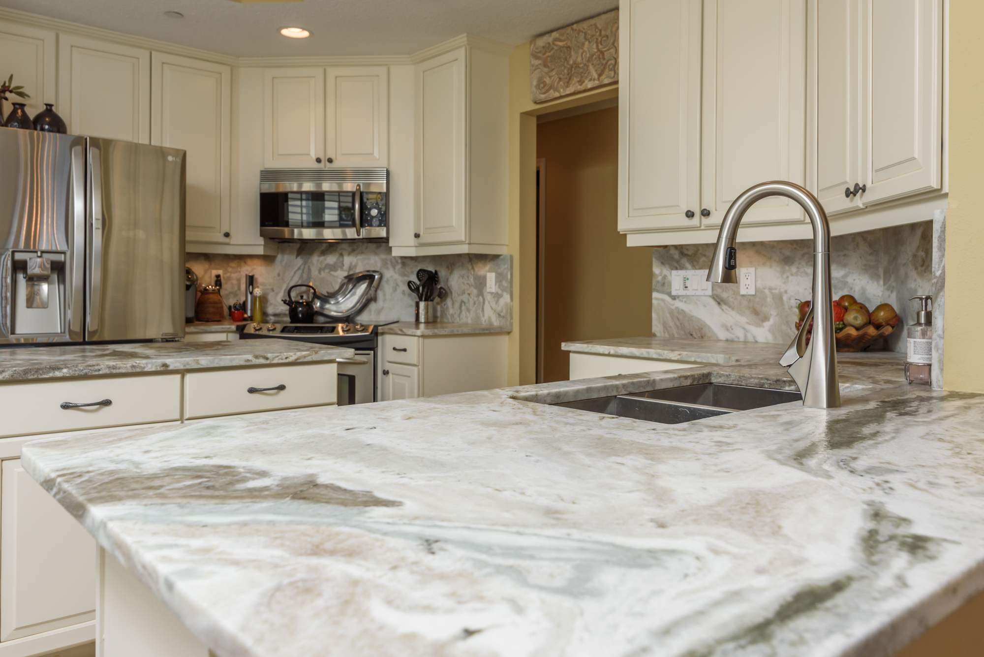 The owners renovated the kitchen when they moved in several years ago. Cabinets painted a creamy white were installed, along with stainless steel appliances. Honed granite countertops with matching backsplash complete the look.