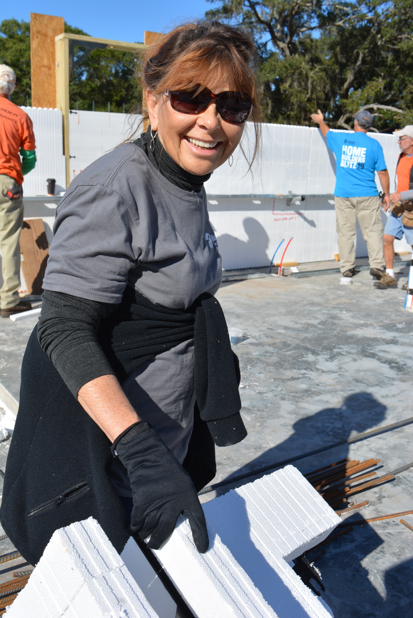 Lak Club resident Stephanie Lang helps put create framing for a future wall with an insulated concrete form.