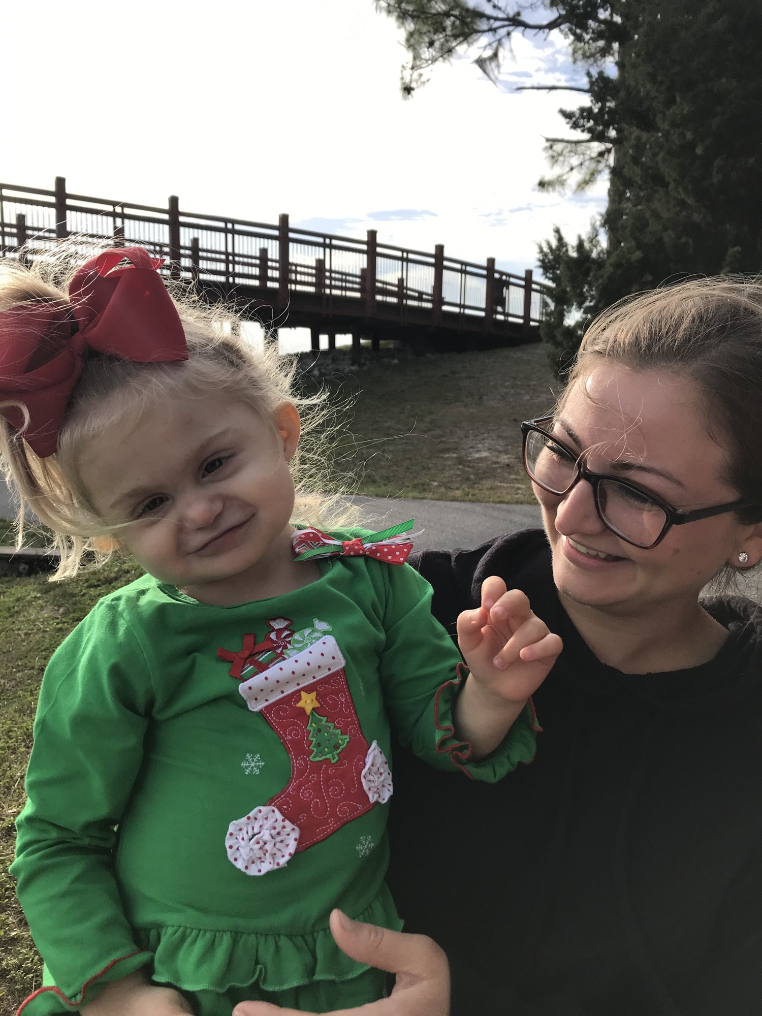 Katrina Michel (right) holds her daughter, Lili, on Dec. 21 at Nathan Benderson Park. Lili has CHARGE syndrome, a disorder that has her caused her to be deaf, blind in one eye and unable to walk