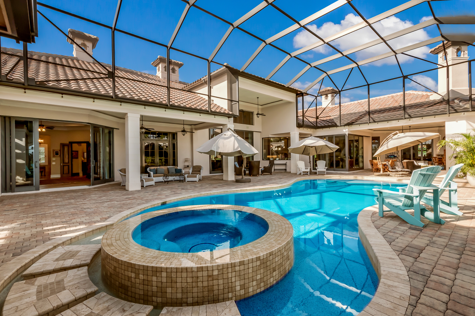 The oversized outdoor living area offers a pool and spa, plus an outdoor kitchen and plenty of seating.