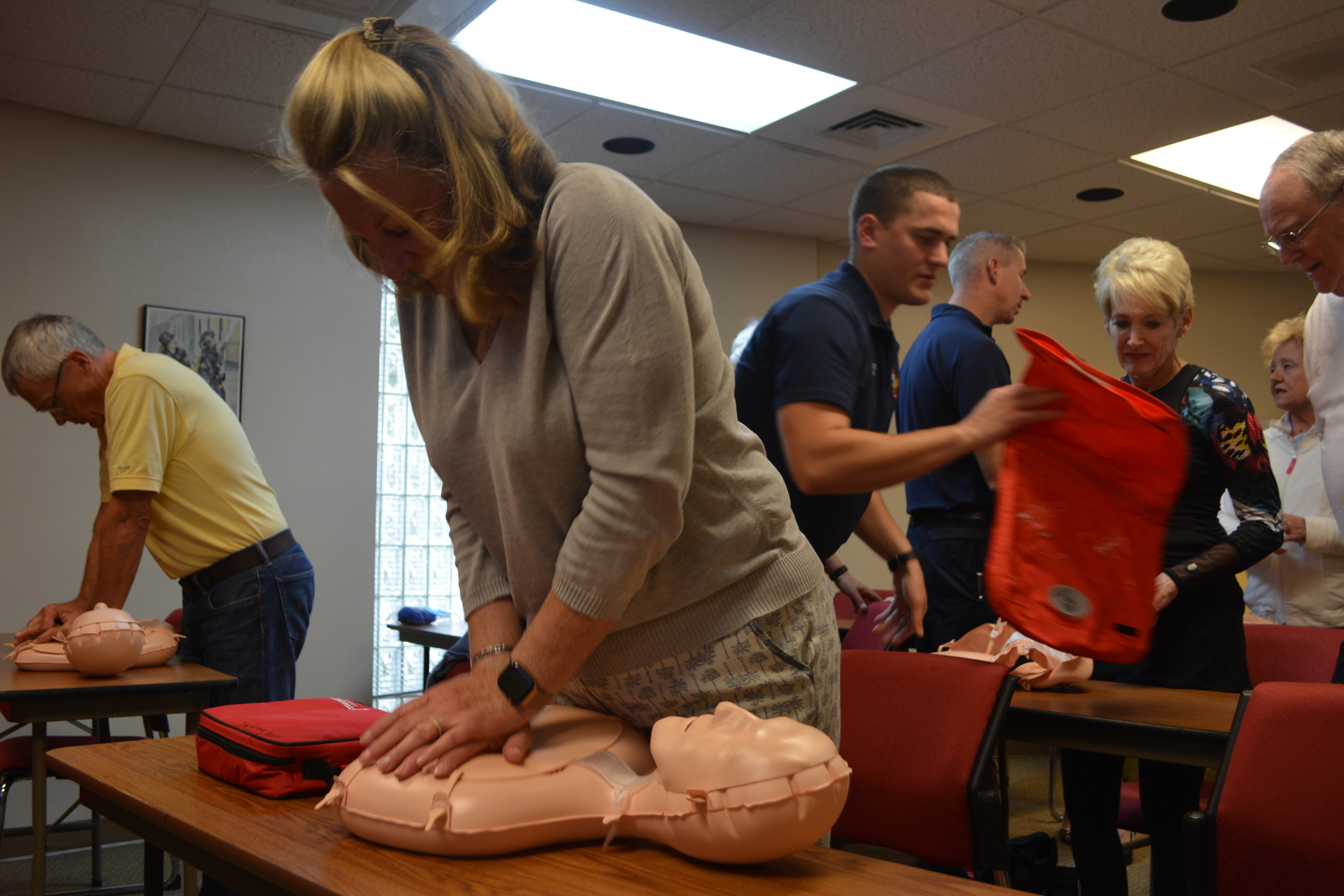 Andrea DeFeo (foreground) practices giving hands-only CPR on a dummy Jan. 23 at the Longboat Key fire station.