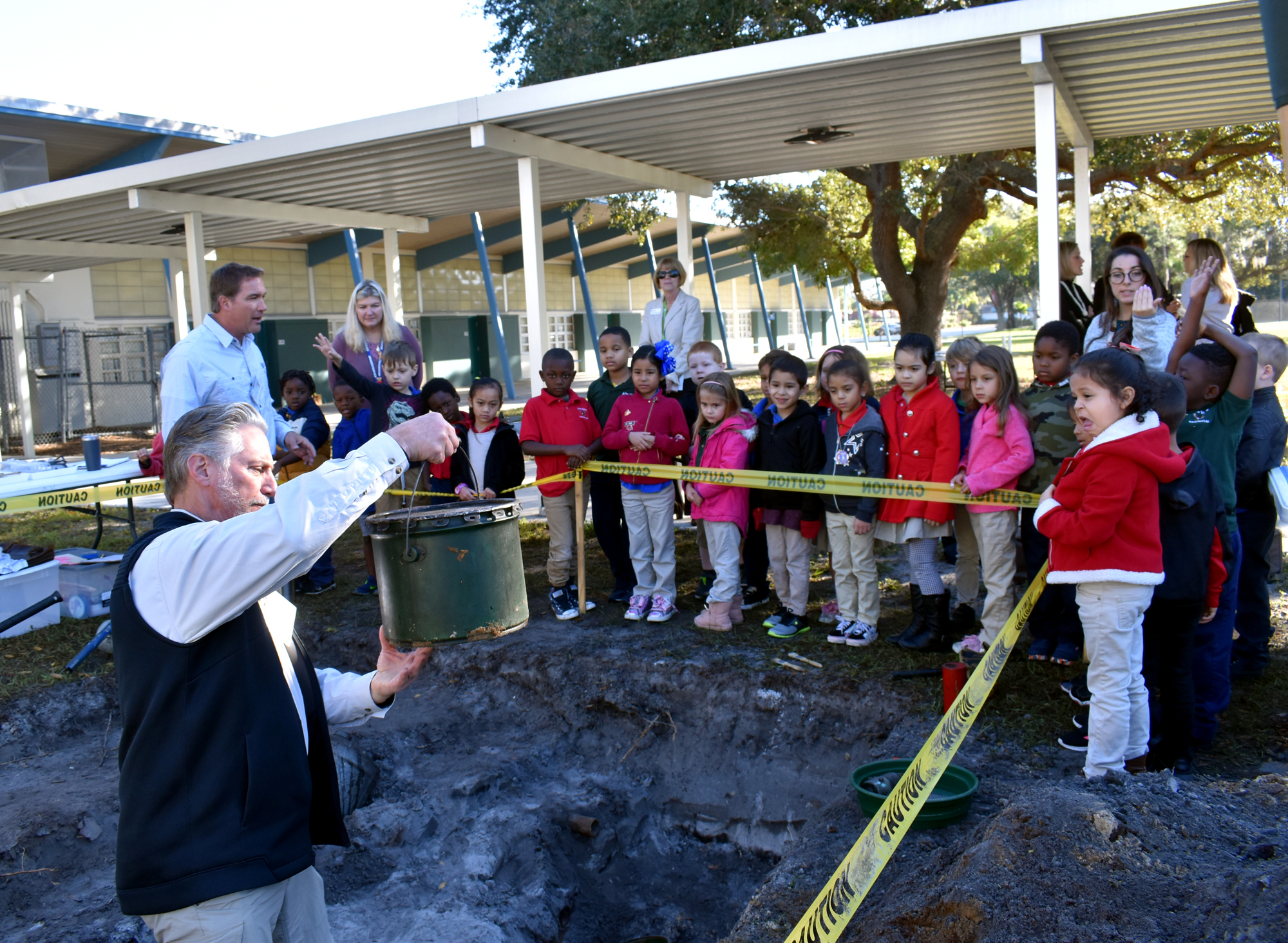 USF's Dana Zeidler shows kindergarten students a barrel he found in the site.