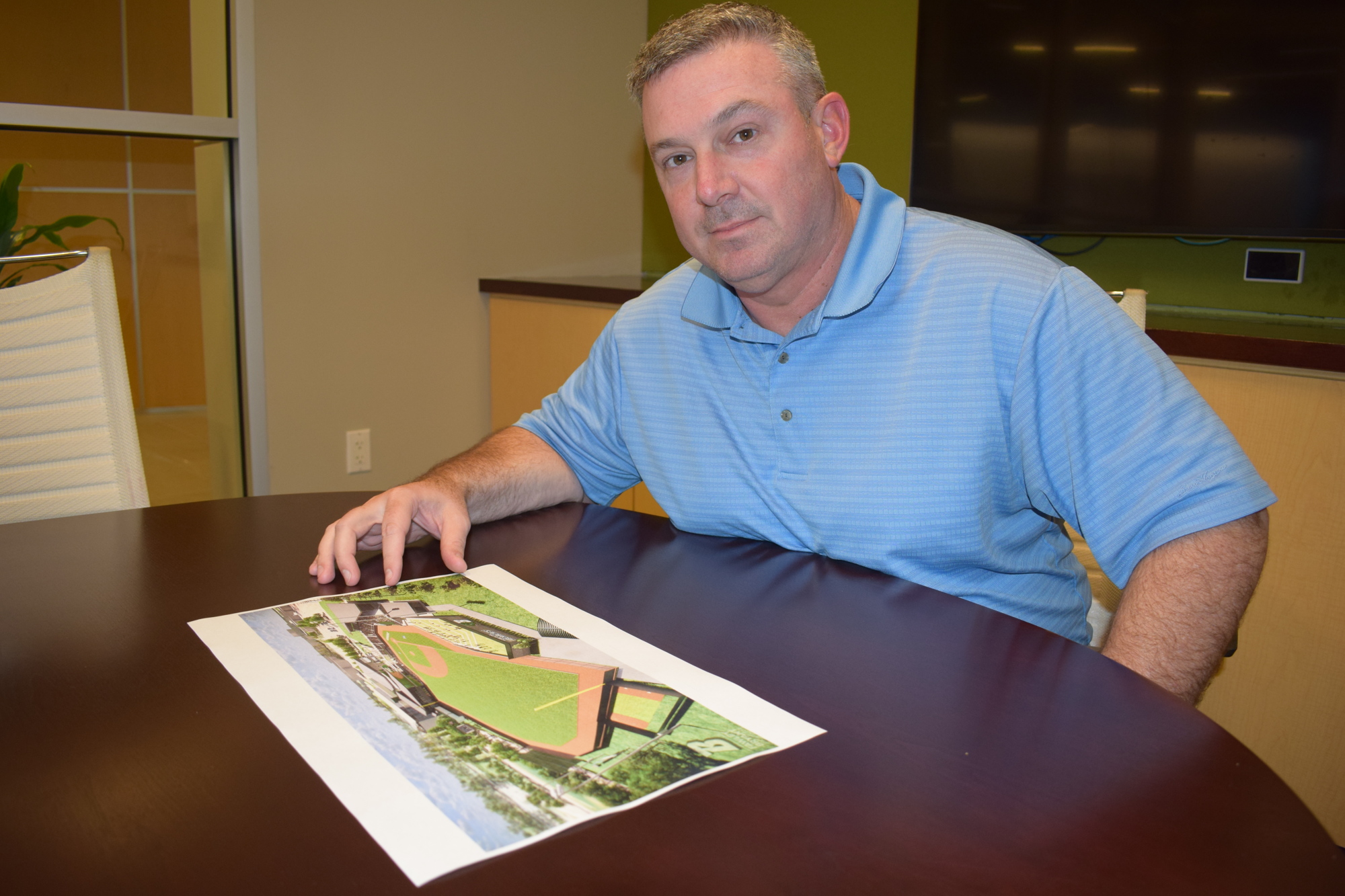 Steve Padgett looks over a rendering of the Binghamton University baseball complex.