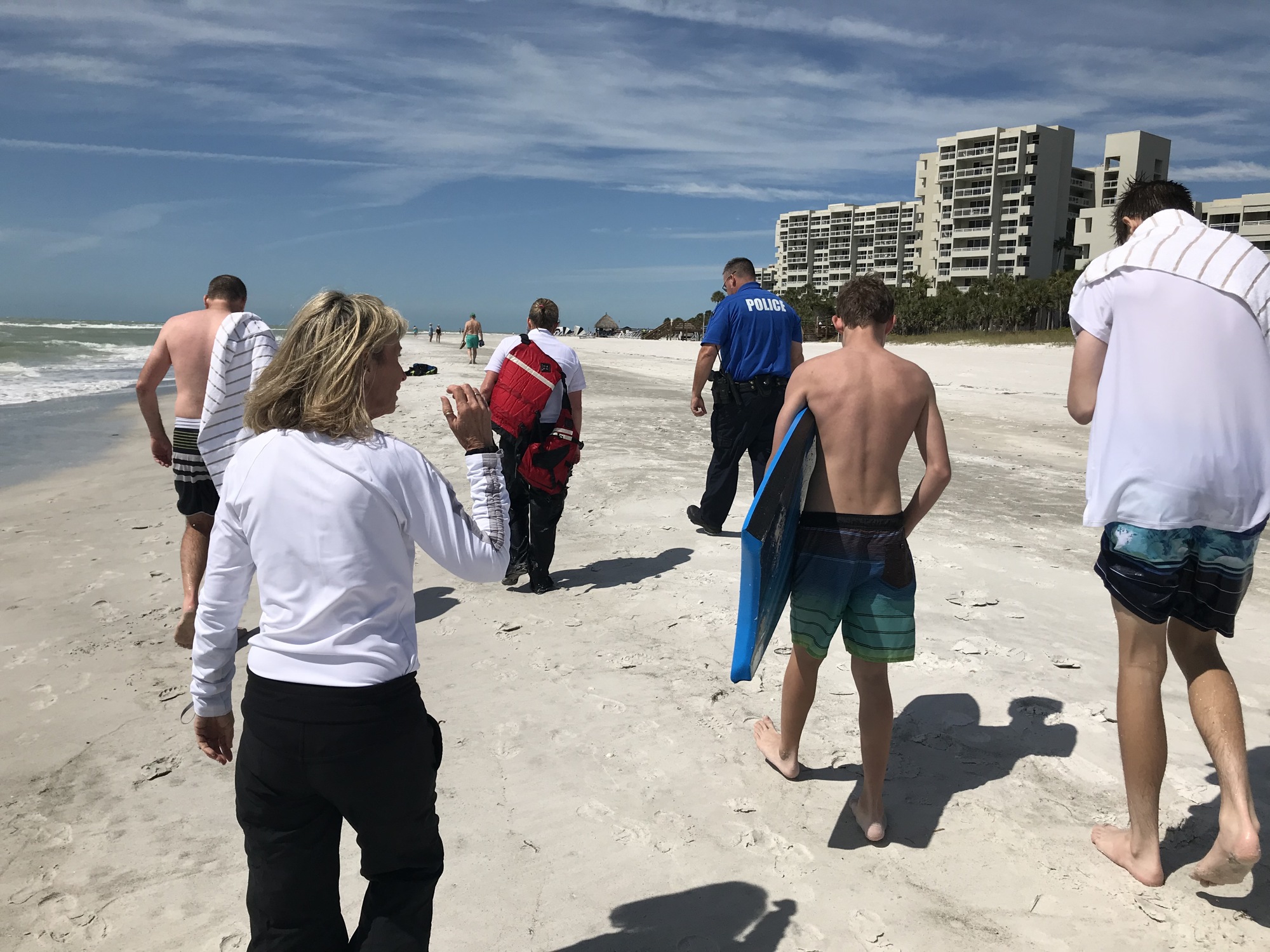 First responders walk on the beach with the family that was affected by the rip current March 6 near Longboat Key Club. (Photo courtesy of the Longboat Key Fire Rescue Department)
