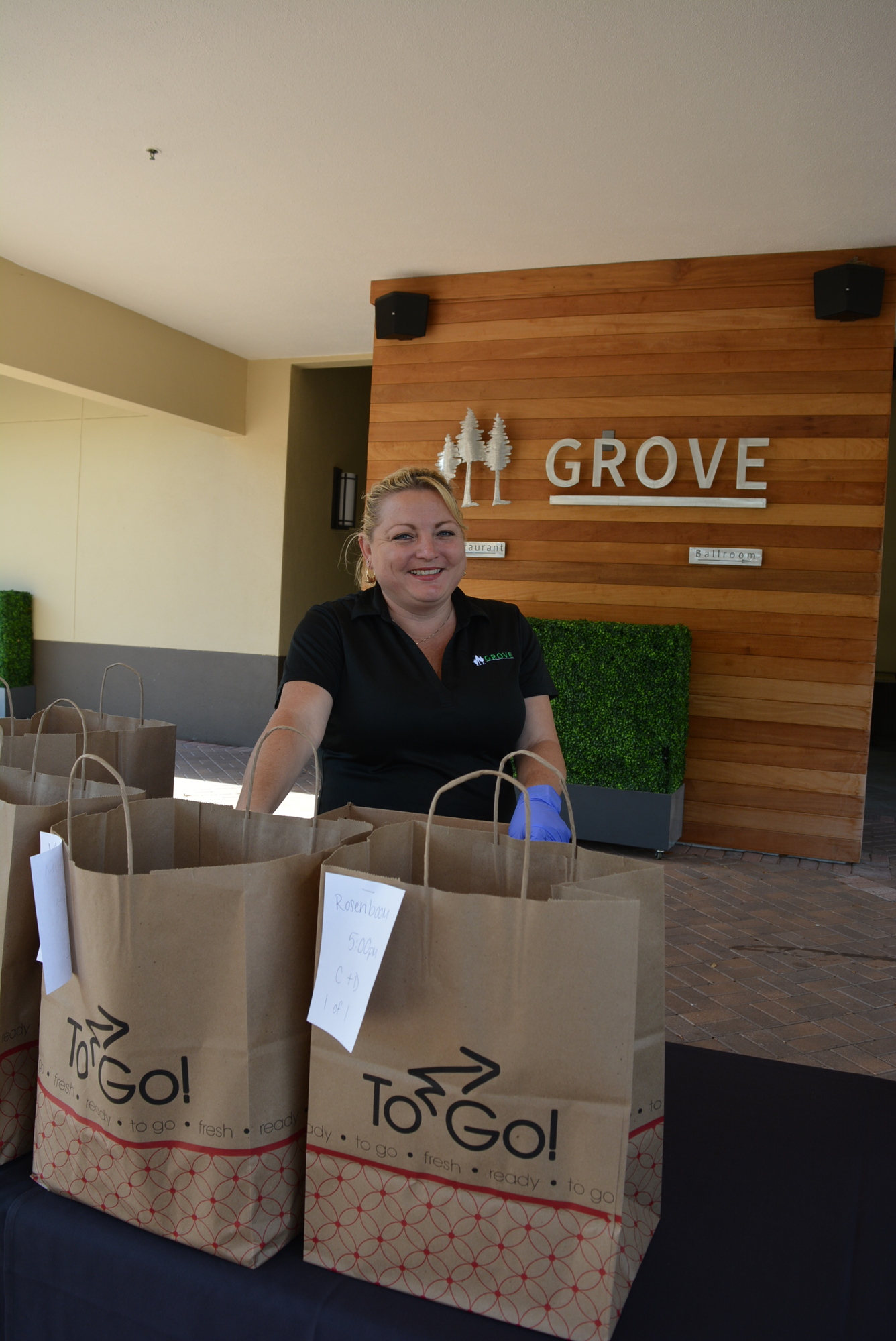 Grove server Delilah Donoho delivers dry goods for customers using the restaurant's online market offering.